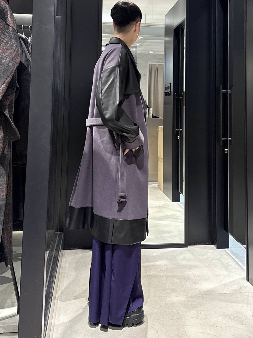 パープル系のトレンチコート、パープル系のスラックスを着用したメンズの秋コーディネートの2枚目の写真