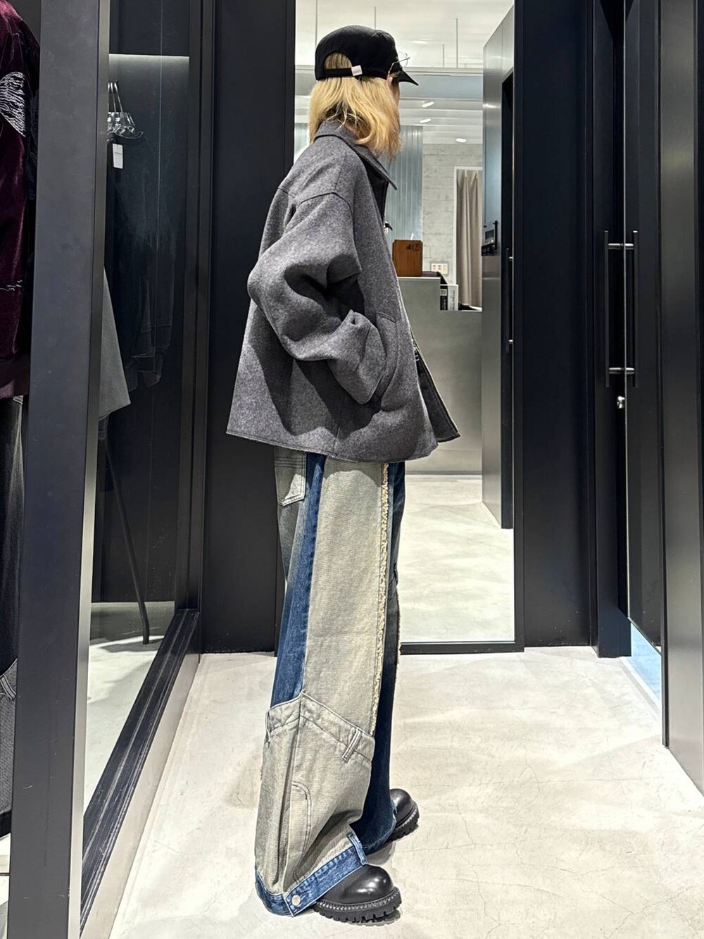 グレー系のブルゾン、ブルー系のデニムパンツ、ブラック系のその他シューズを着用したメンズの秋コーディネートの2枚目の写真