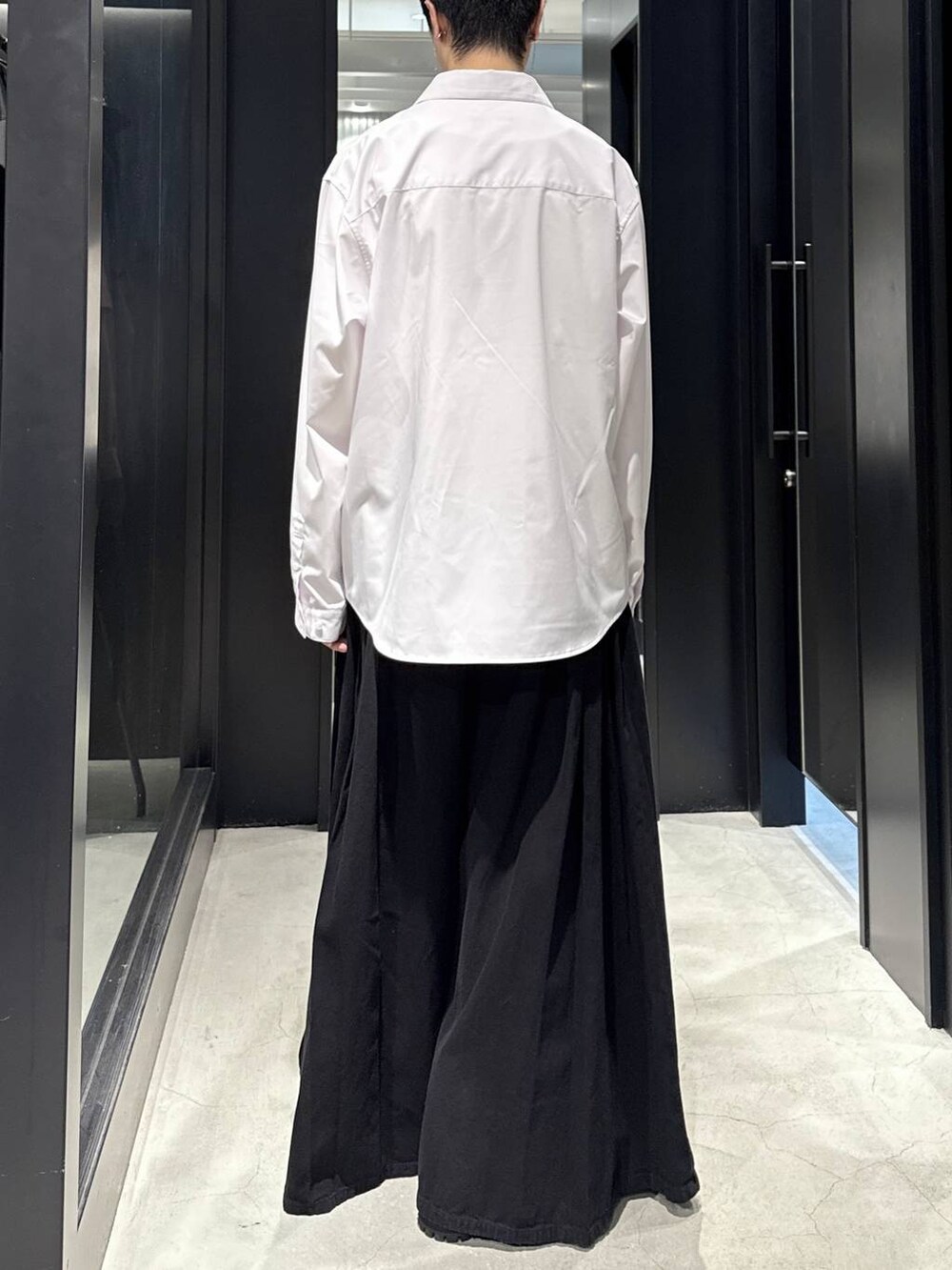 ホワイト系のTシャツ/カットソー、ブラック系のデニムパンツ、ブラック系のブーツを着用したメンズの秋コーディネートの3枚目の写真