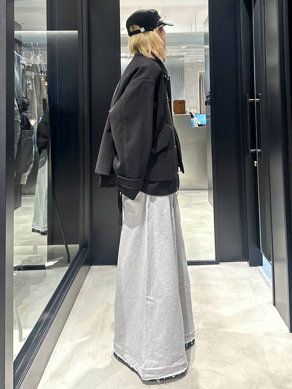 グレー系のスウェットパンツ、ブラック系のブルゾン、ブラック系のキャップを着用したメンズの秋コーディネートの2枚目の写真