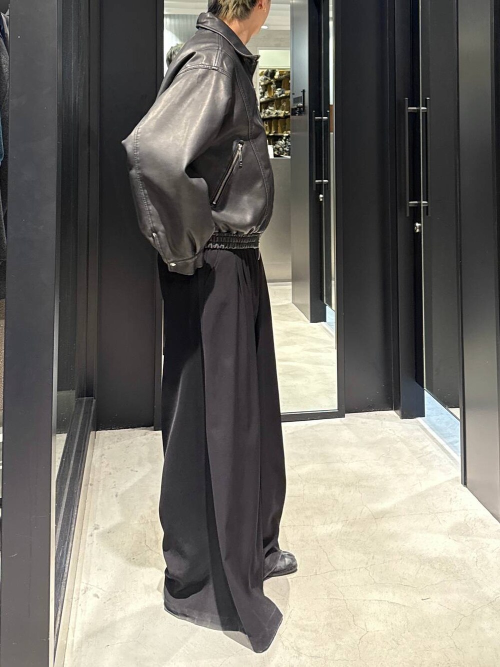 ブラック系のスラックス、ブラック系のブルゾン、シルバー系のネックレスを着用したメンズの冬コーディネートの2枚目の写真