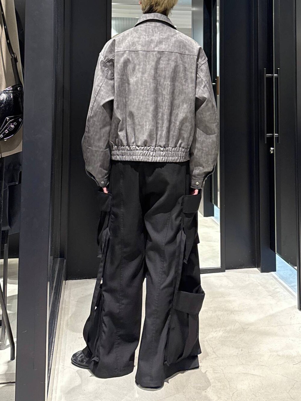 ブラック系のTシャツ/カットソー、グレー系のブルゾン、ブラック系のカーゴパンツを着用したメンズの冬コーディネートの2枚目の写真