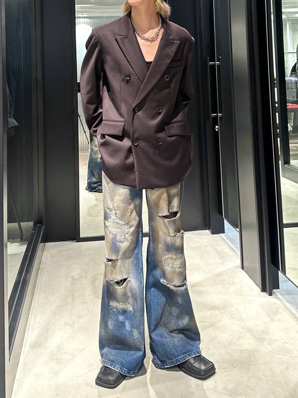 ブラウン系のテーラードジャケット、ブルー系のデニムパンツ、シルバー系のネックレスを着用したメンズの秋コーディネートの2枚目の写真