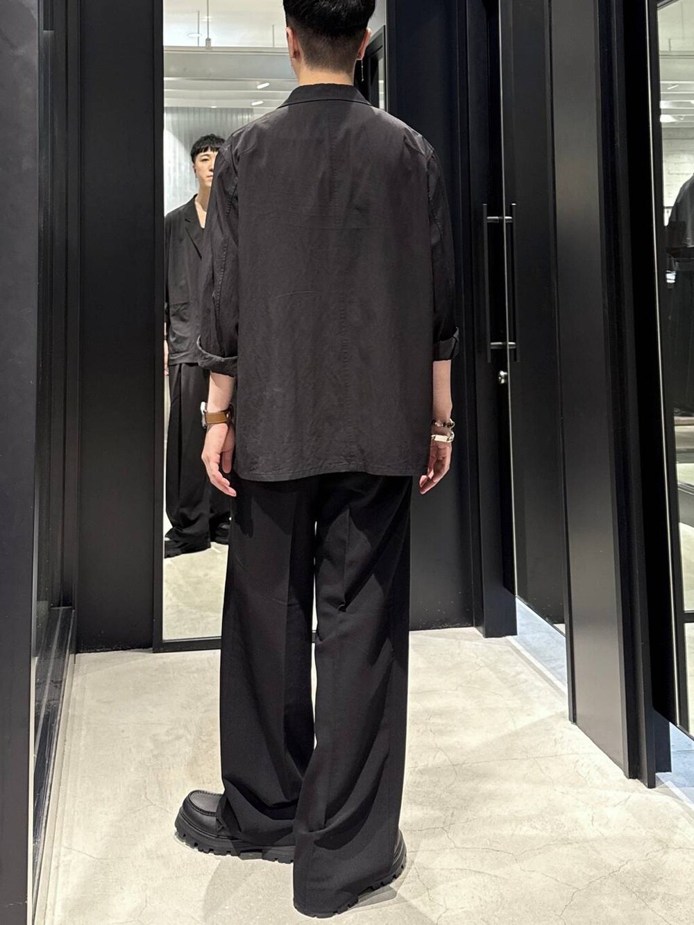 ブラック系のテーラードジャケット、ブラック系のドレスシューズ、ブラック系のスラックスを着用したメンズの秋コーディネートの3枚目の写真