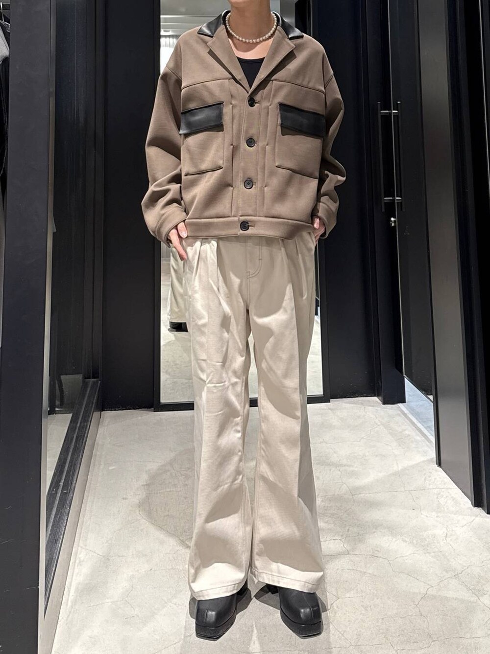 ブラック系のブーツ、ホワイト系のデニムパンツ、ベージュ系のブルゾンを着用したメンズの冬コーディネートの2枚目の写真