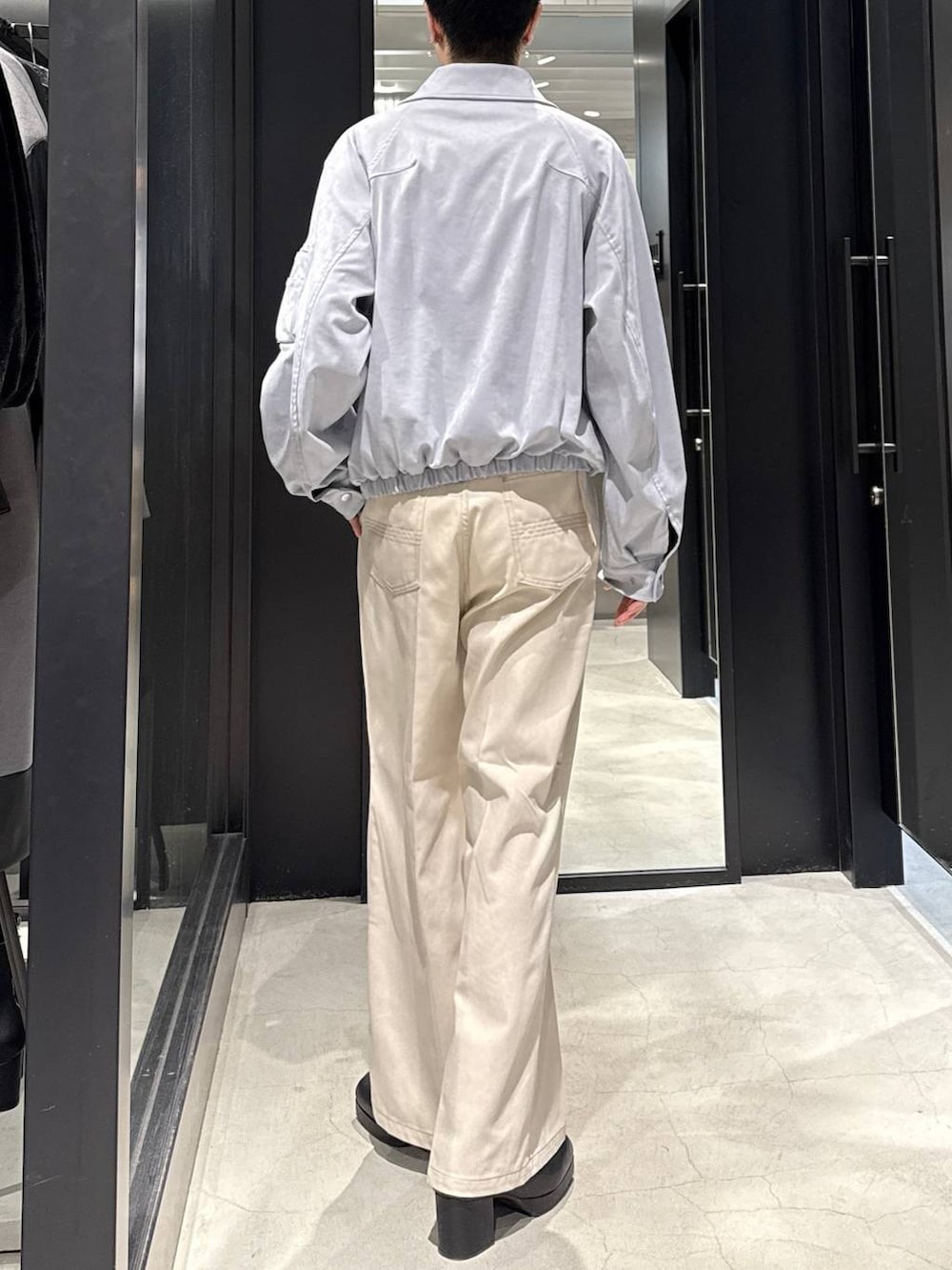 ブルー系のブルゾン、ブラック系のブーツ、ホワイト系のデニムパンツを着用したメンズの冬コーディネートの3枚目の写真