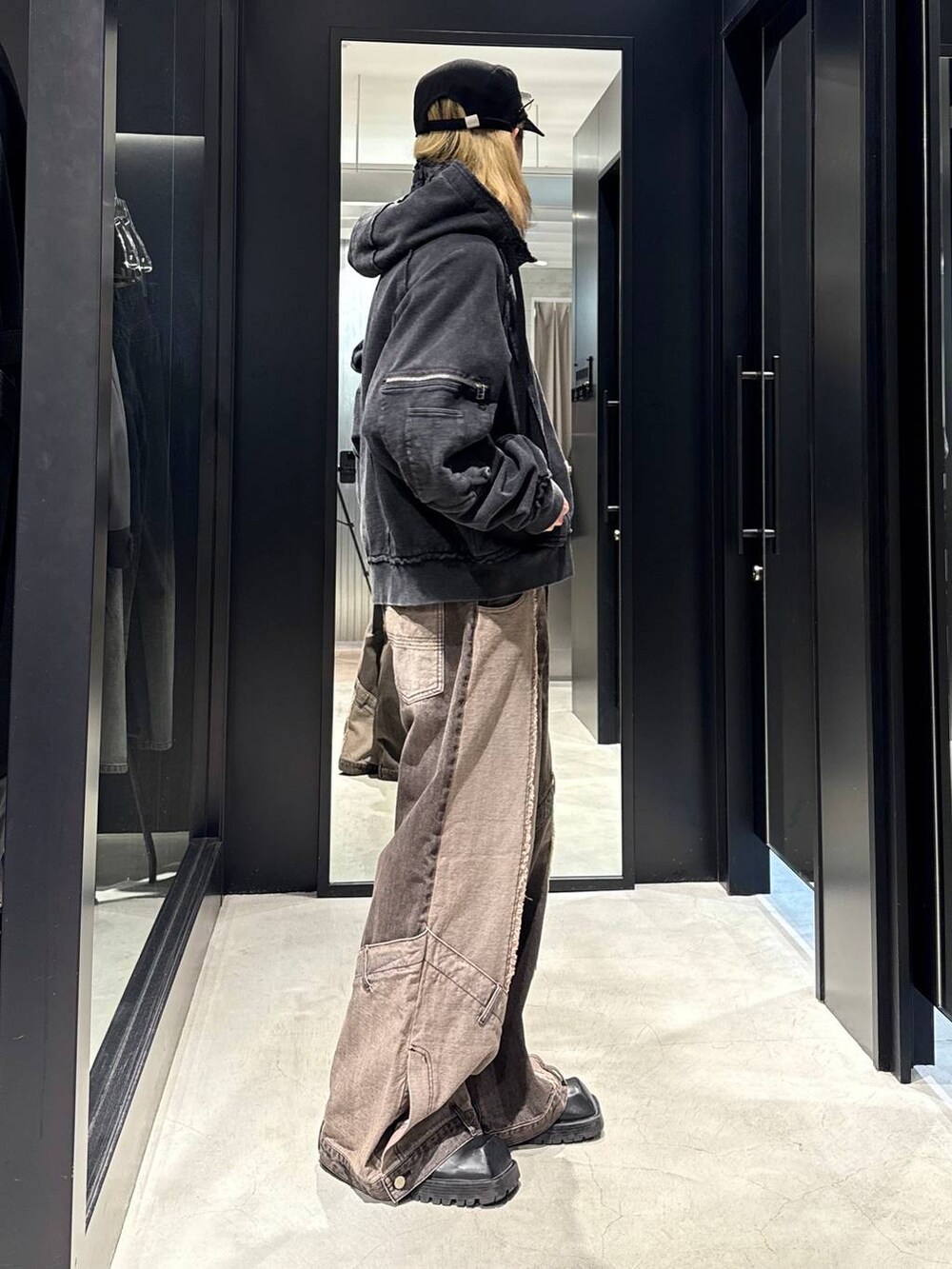 ブラウン系のデニムパンツ、ブラック系のパーカー、ブラック系のキャップを着用したメンズの秋コーディネートの2枚目の写真