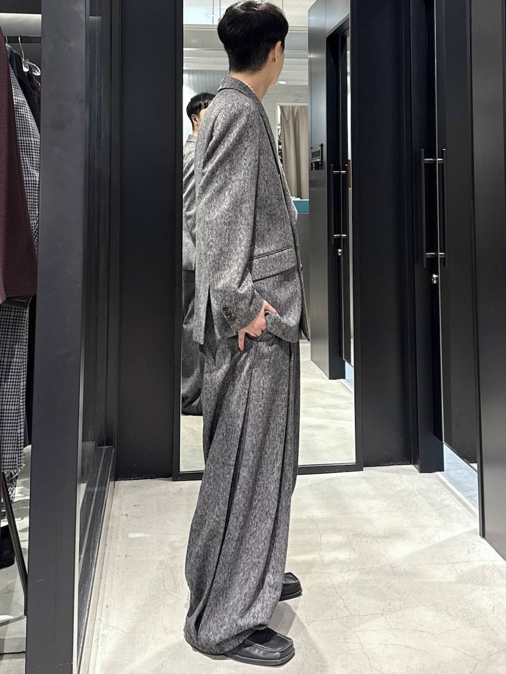 ブラック系のスラックス、ブラック系のテーラードジャケットを着用したメンズの秋コーディネートの2枚目の写真