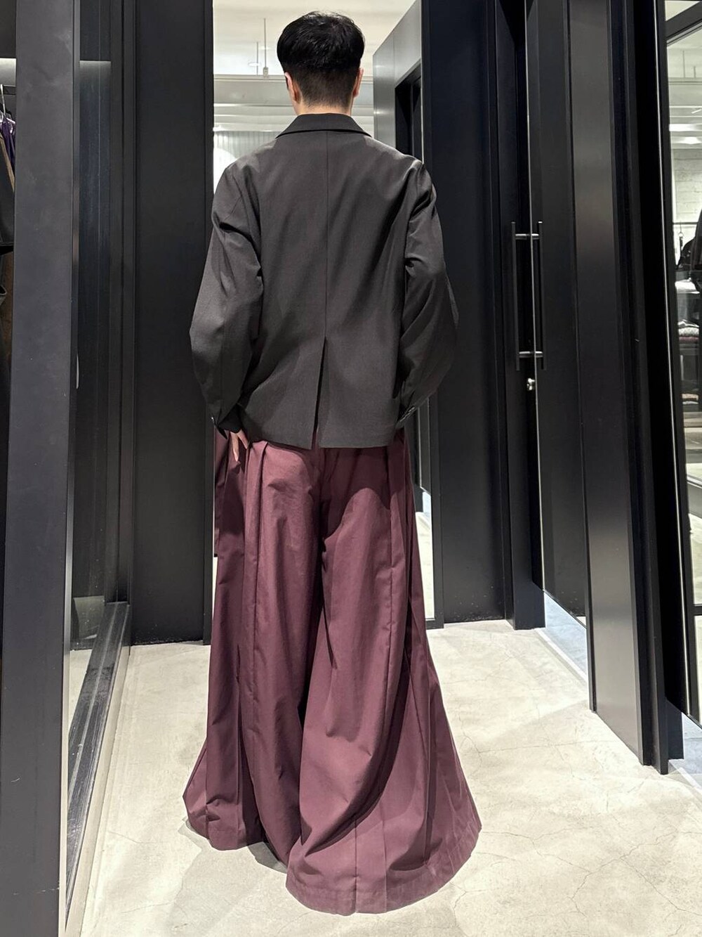 ブラック系のブーツ、レッド系のその他パンツ、ブラック系のテーラードジャケットを着用したメンズの秋コーディネートの3枚目の写真