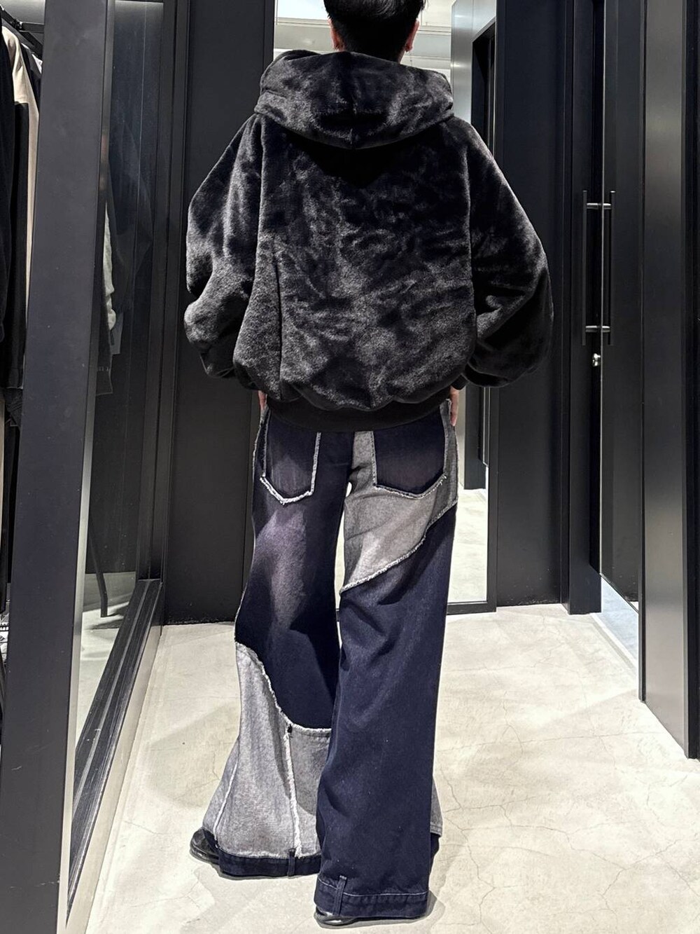 ブラック系のブルゾン、ブルー系のデニムパンツ、ブラック系のスウェットを着用したメンズの秋コーディネートの3枚目の写真