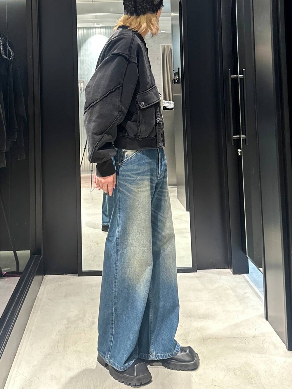 ブルー系のデニムパンツ、ブラック系のブルゾン、シルバー系のネックレスを着用したメンズの秋コーディネートの2枚目の写真