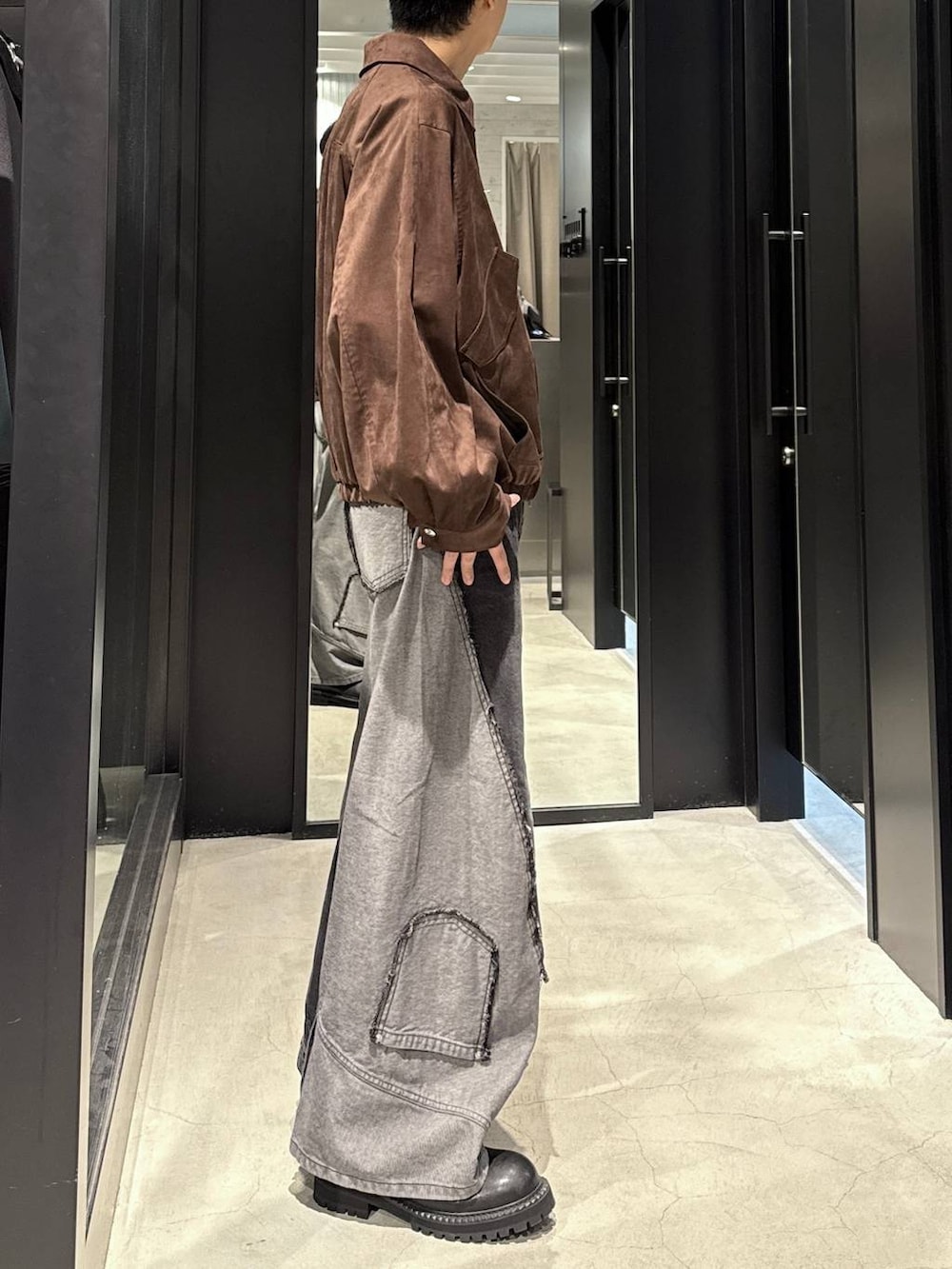 ブラック系のデニムパンツ、ブラウン系のブルゾン、ブラック系のTシャツ/カットソーを着用したメンズの秋コーディネートの2枚目の写真