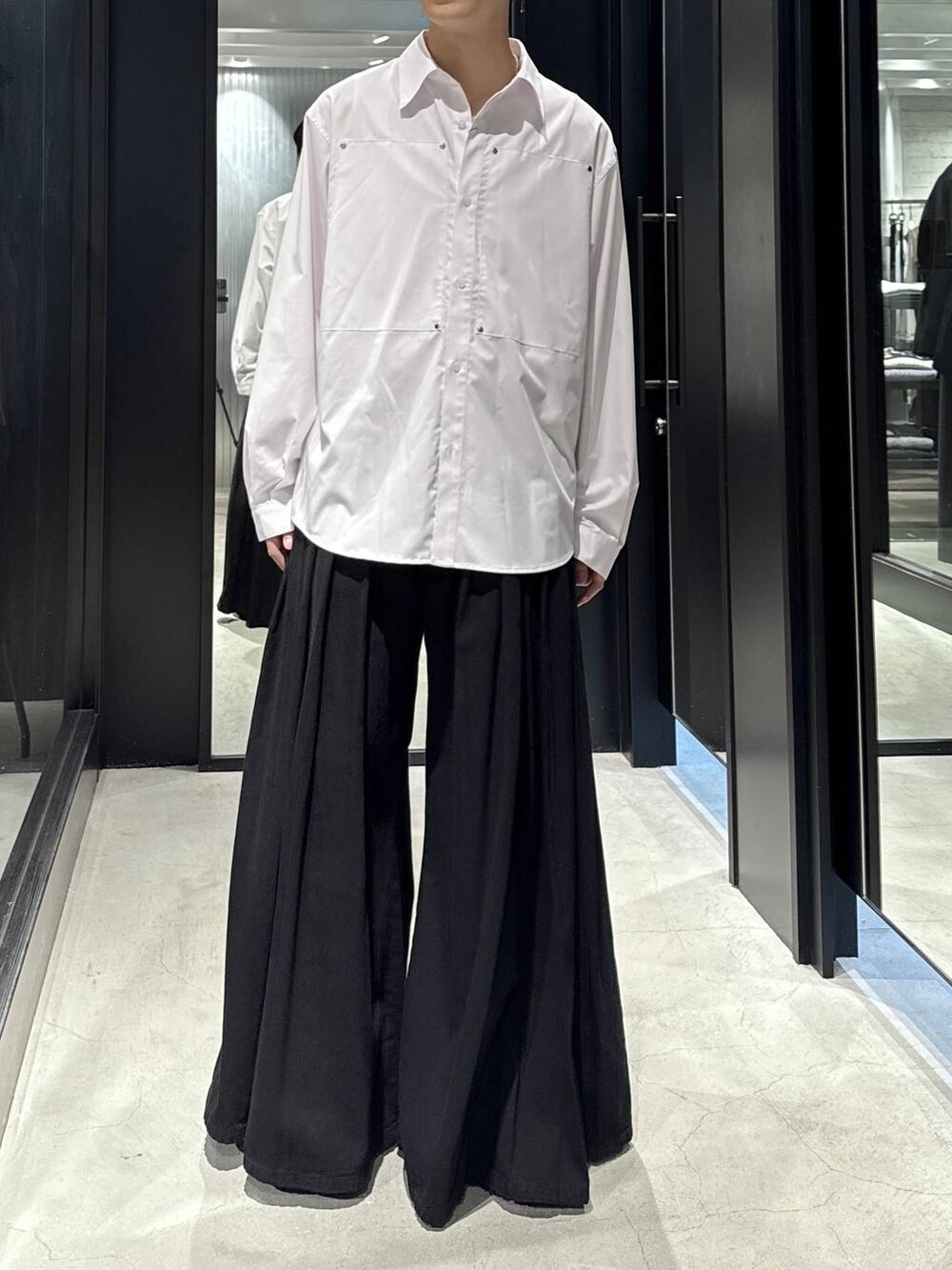 ホワイト系のTシャツ/カットソー、ブラック系のデニムパンツ、ブラック系のブーツを着用したメンズの秋コーディネートの4枚目の写真