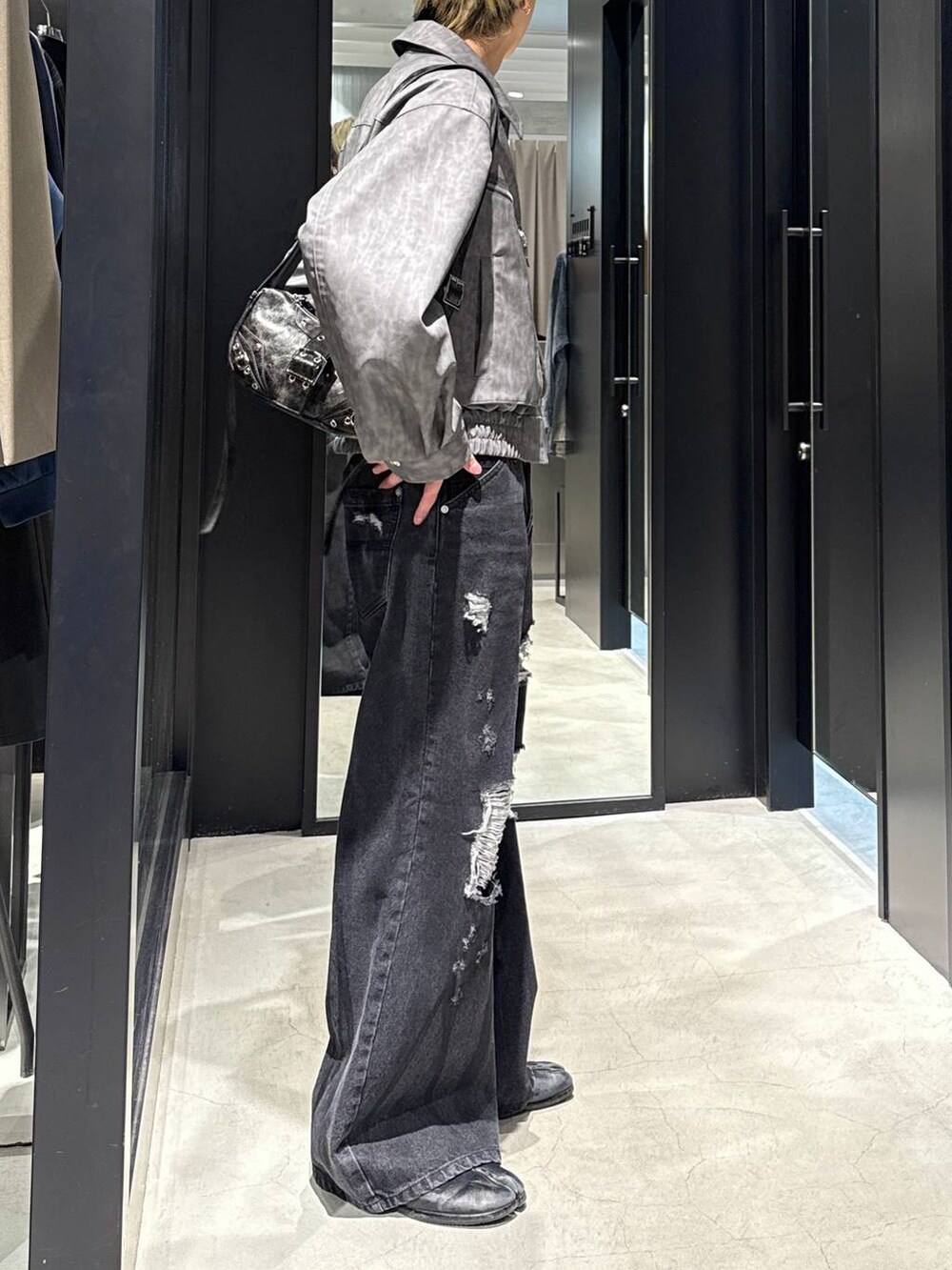 ブラック系のTシャツ/カットソー、ブラック系のショルダーバッグ、ブラック系のデニムパンツを着用したメンズの冬コーディネートの2枚目の写真