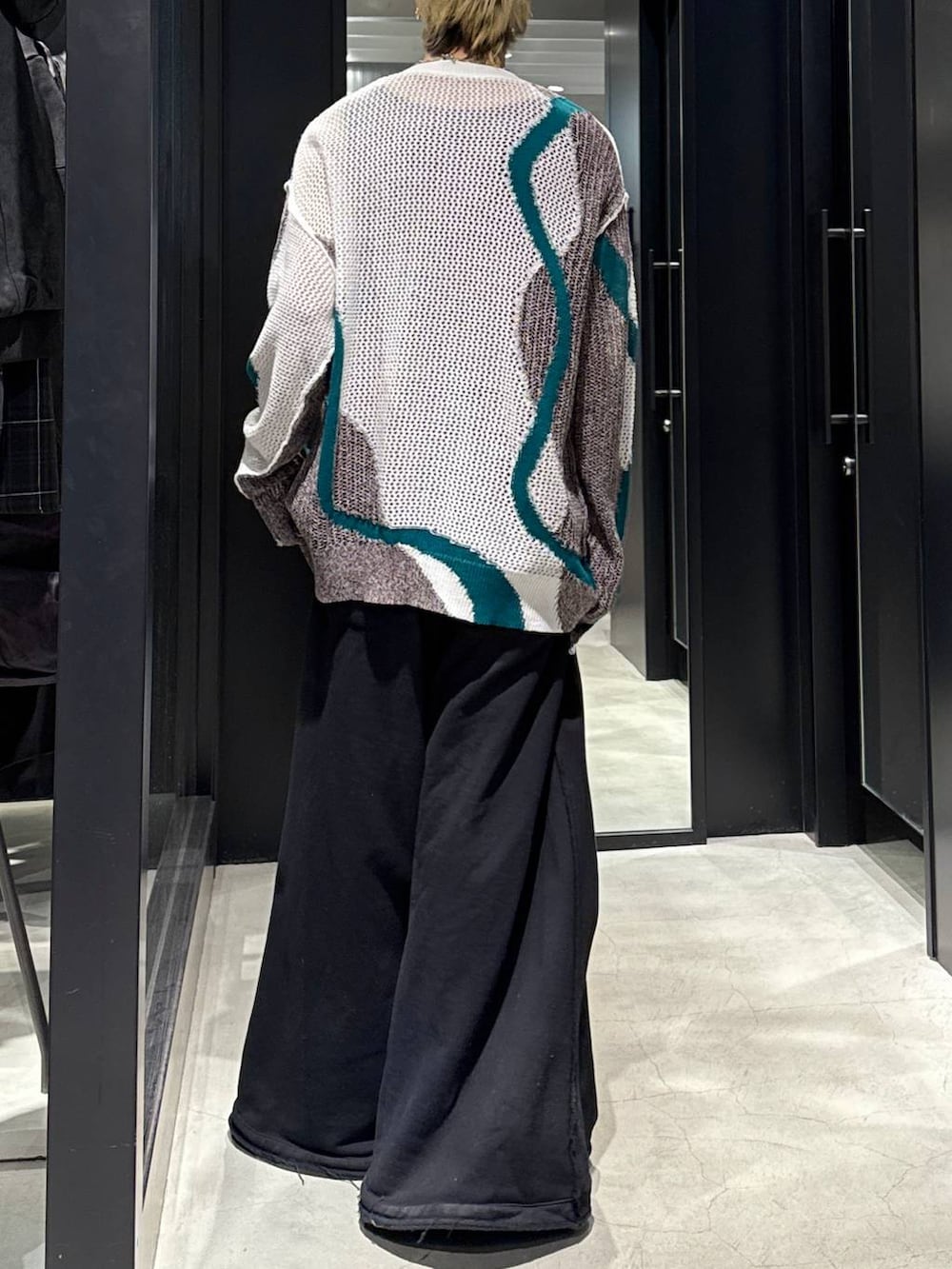 ブラック系のスウェットパンツ、ホワイト系のカーディガン/ボレロ、ブラック系のキャップを着用したメンズの春コーディネートの3枚目の写真