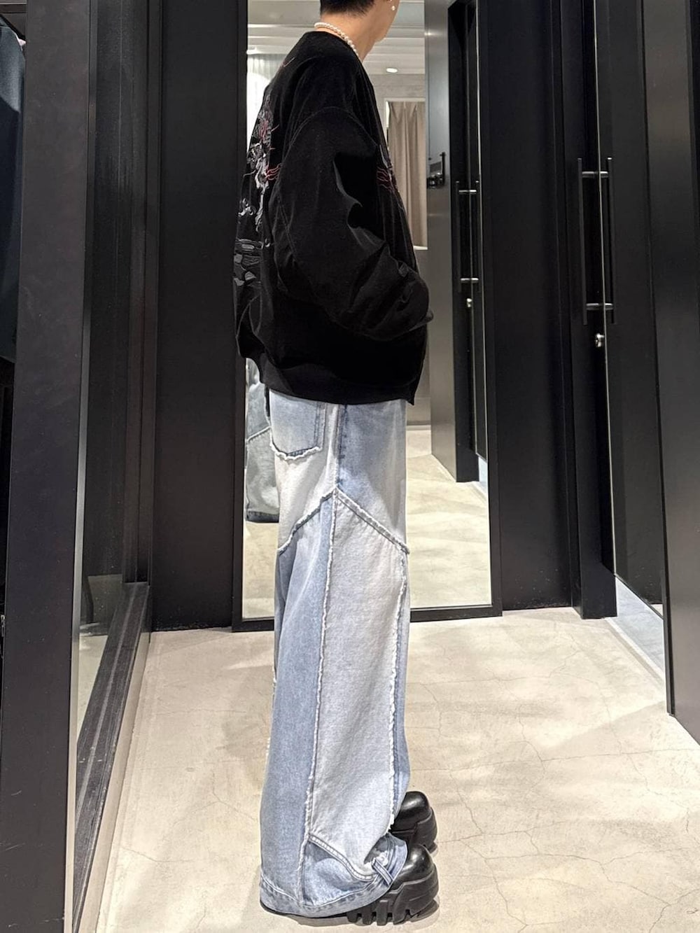 ブラック系のスカジャン、ホワイト系のネックレスを着用したメンズの冬コーディネートの2枚目の写真