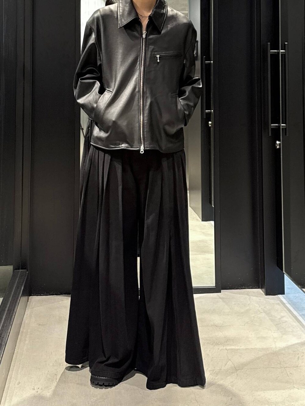 ホワイト系のTシャツ/カットソー、ブラック系のデニムパンツ、ブラック系のブルゾンを着用したメンズの秋コーディネートの4枚目の写真