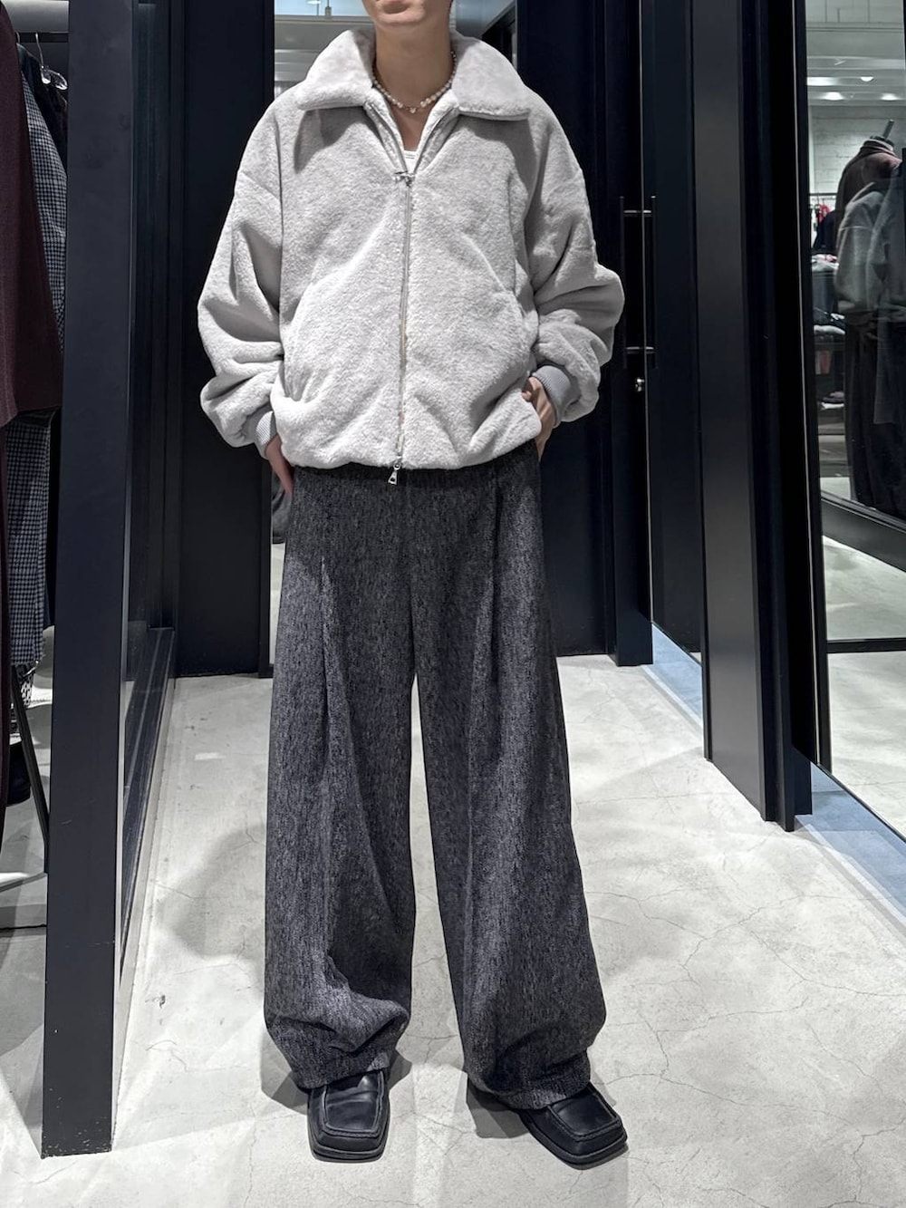 グレー系のブルゾン、ブラック系のスラックスを着用したメンズの秋コーディネートの4枚目の写真