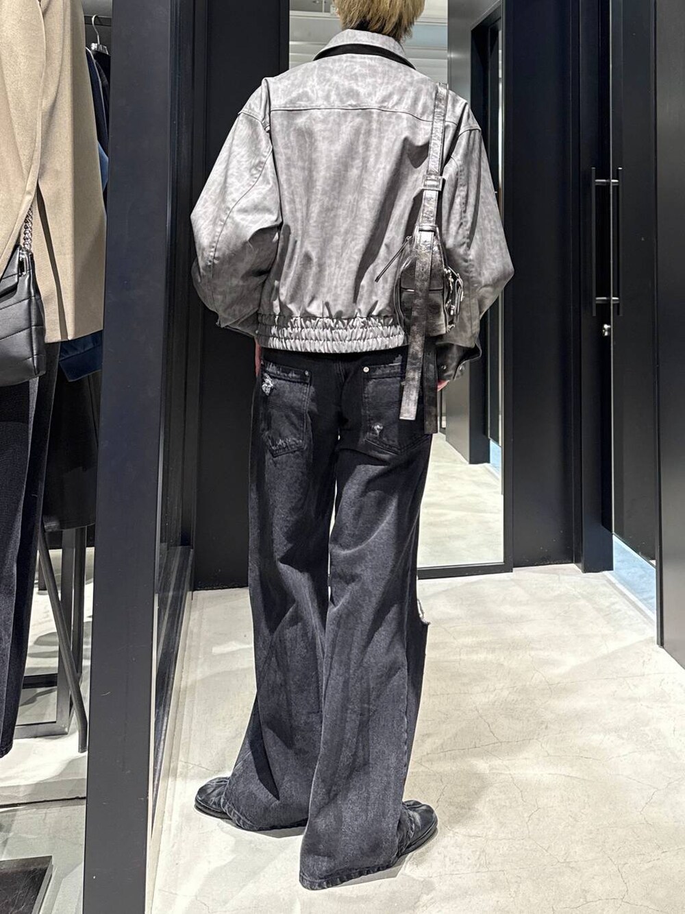 ブラック系のTシャツ/カットソー、ブラック系のショルダーバッグ、ブラック系のデニムパンツを着用したメンズの冬コーディネートの3枚目の写真