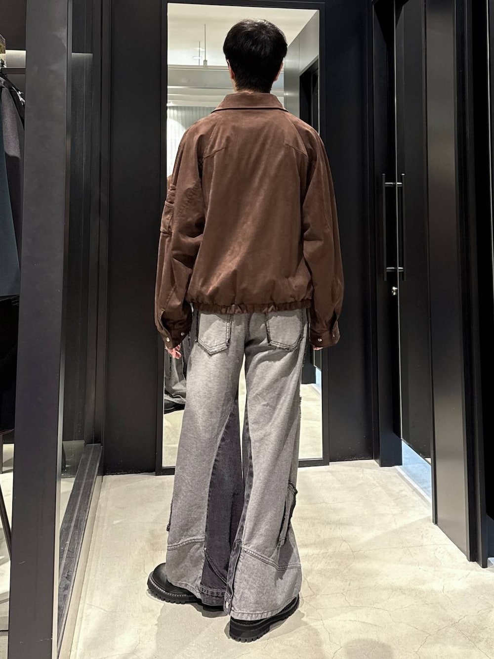 ブラック系のデニムパンツ、ブラウン系のブルゾン、ブラック系のTシャツ/カットソーを着用したメンズの秋コーディネートの3枚目の写真