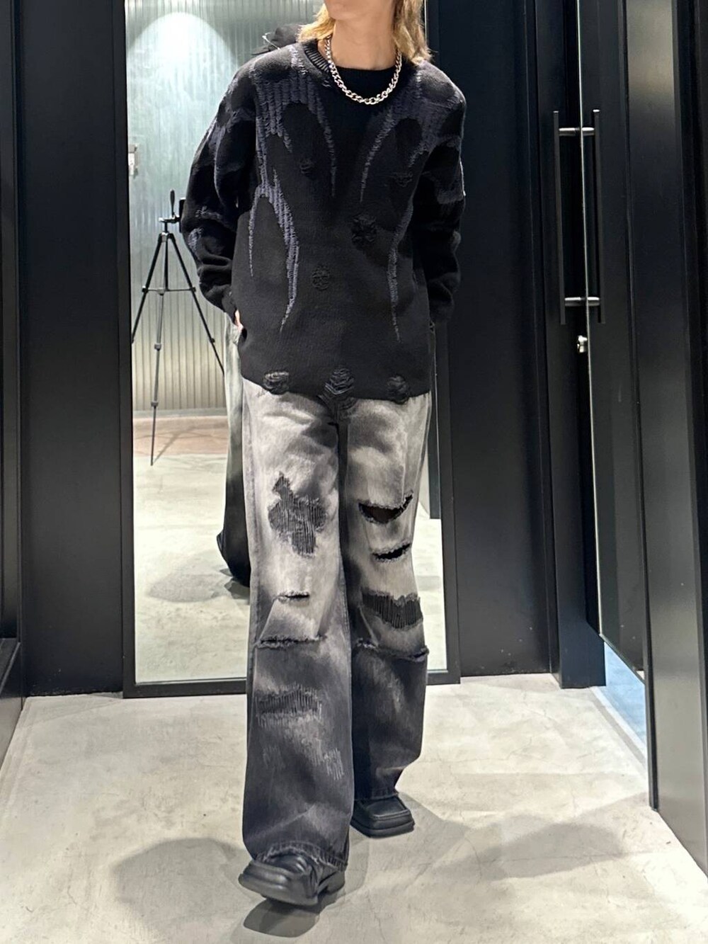 ブラック系のデニムパンツ、ブラック系のニット/セーター、ブラック系のキャップを着用したメンズの秋コーディネートの3枚目の写真