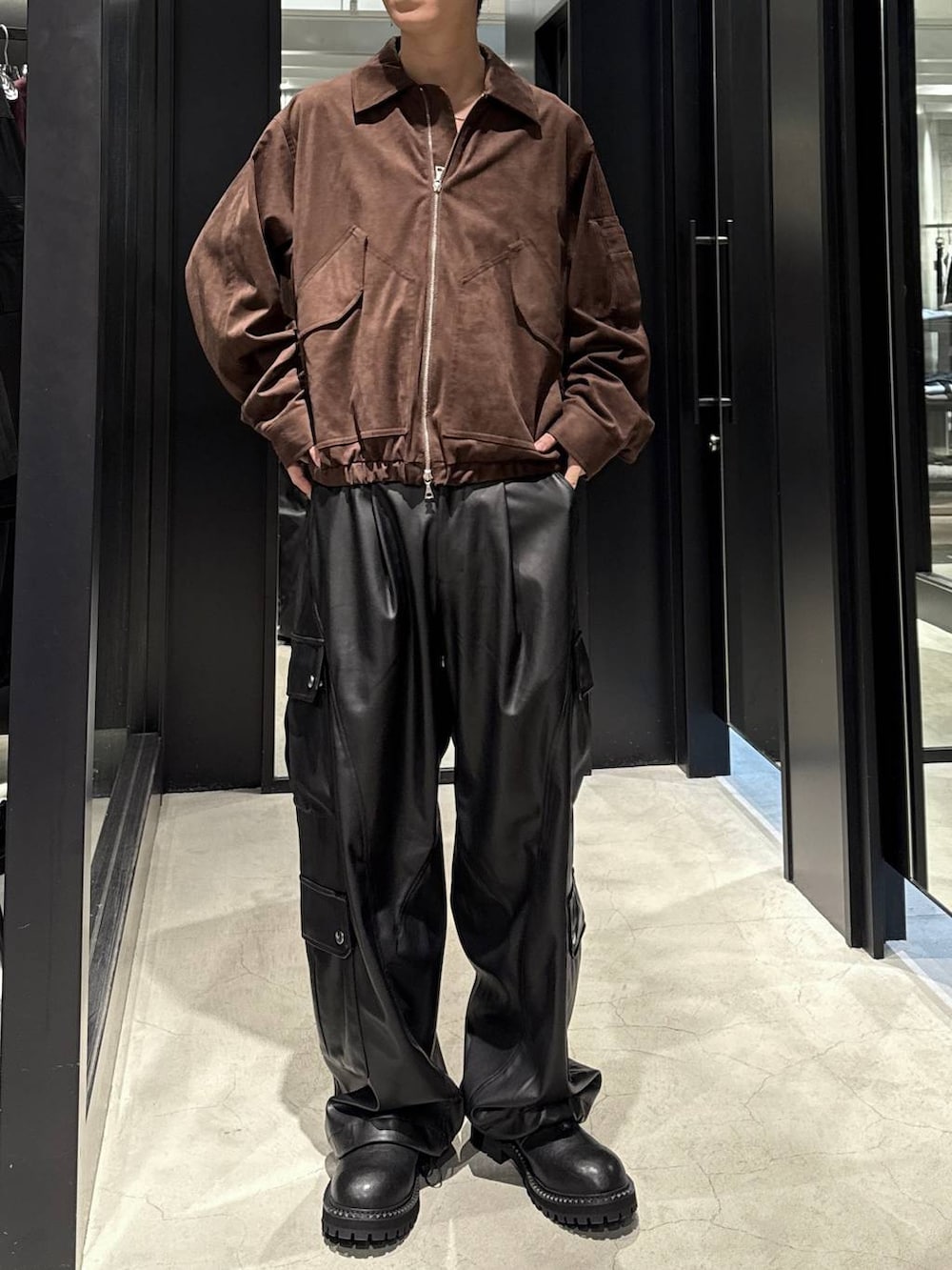 ホワイト系のTシャツ/カットソー、ブラック系のカーゴパンツ、ブラウン系のブルゾンを着用したメンズの秋コーディネートの4枚目の写真