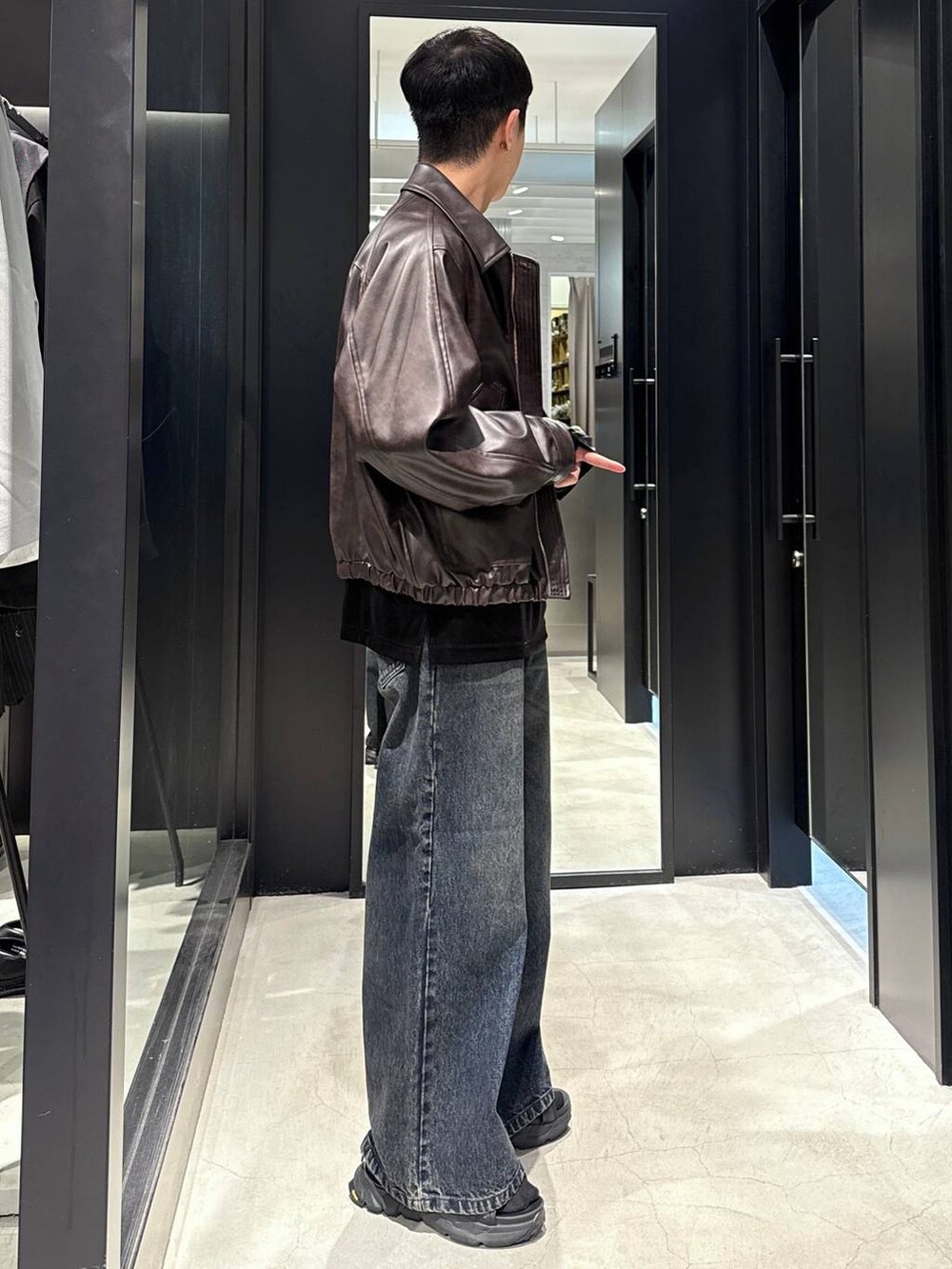 ブラック系のサンダル、ブラウン系のブルゾン、ブルー系のデニムパンツを着用したメンズの夏コーディネートの2枚目の写真