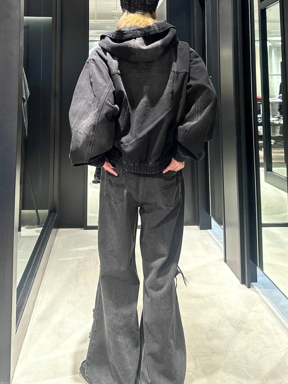 ブラック系のデニムパンツ、ブラック系のブルゾン、シルバー系のネックレスを着用したメンズの秋コーディネートの4枚目の写真