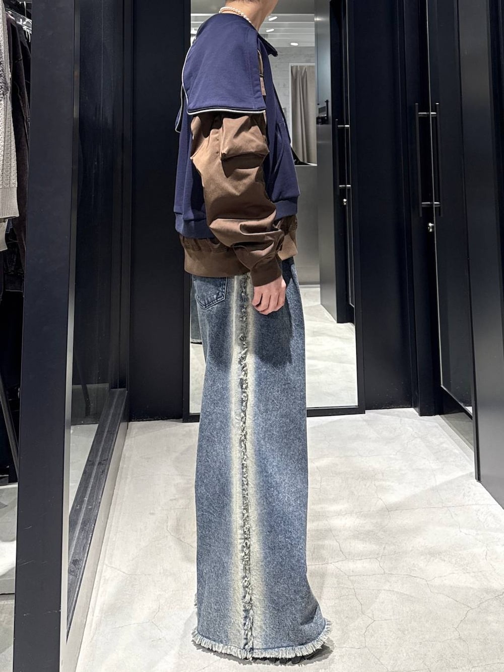 ブルー系のデニムパンツ、ブルー系のパーカー、ホワイト系のネックレスを着用したメンズの冬コーディネートの2枚目の写真