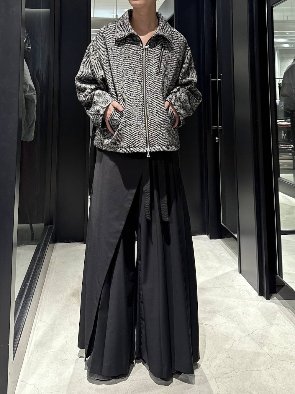 グレー系のブルゾン、ブラック系のスラックスを着用したメンズの冬コーディネートの4枚目の写真