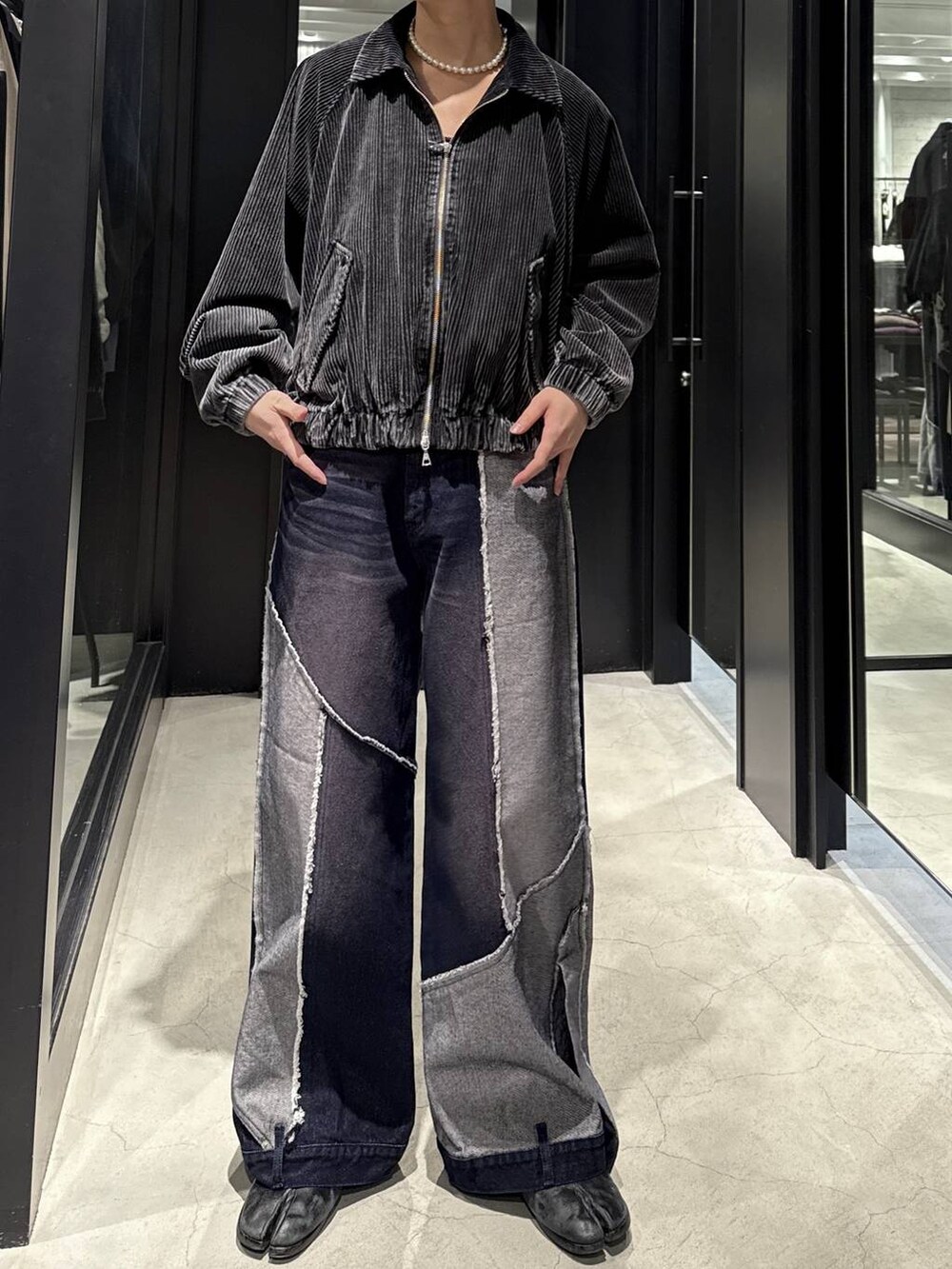 ブラック系のブルゾン、ブルー系のデニムパンツ、ブラック系のスウェットを着用したメンズの秋コーディネートの4枚目の写真