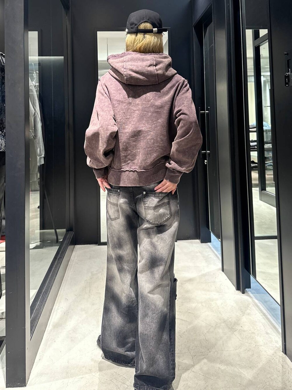 ブラック系のデニムパンツ、ブラウン系のパーカー、ブラック系のキャップを着用したメンズの秋コーディネートの3枚目の写真