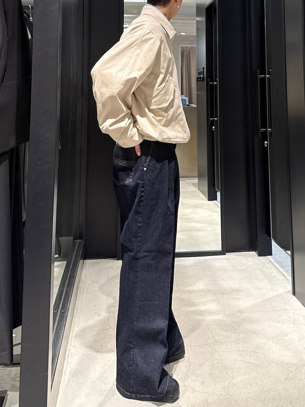 ベージュ系のブルゾン、ブラック系のブーツ、ブルー系のデニムパンツを着用したメンズの冬コーディネートの2枚目の写真