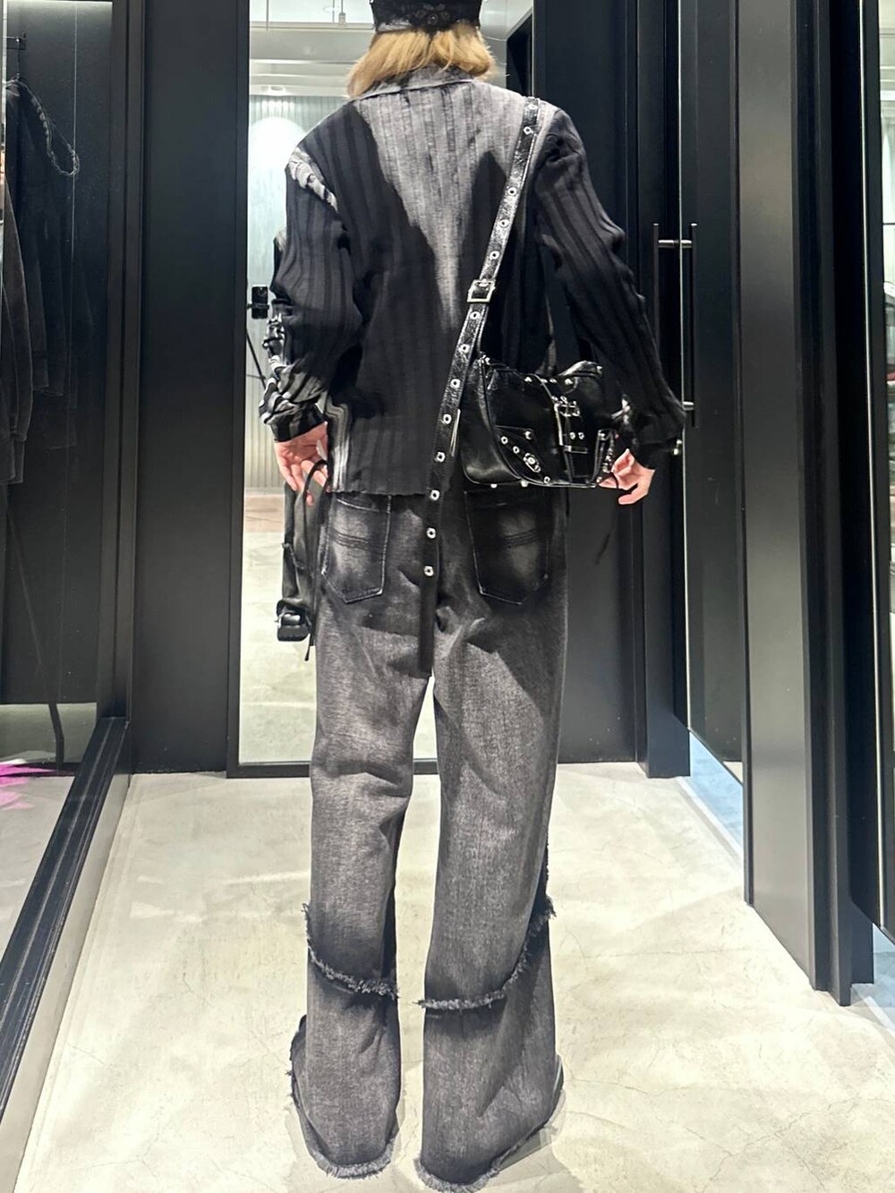 ブラック系のデニムパンツ、ブラック系のショルダーバッグ、ブラック系のニット/セーターを着用したメンズの秋コーディネートの4枚目の写真