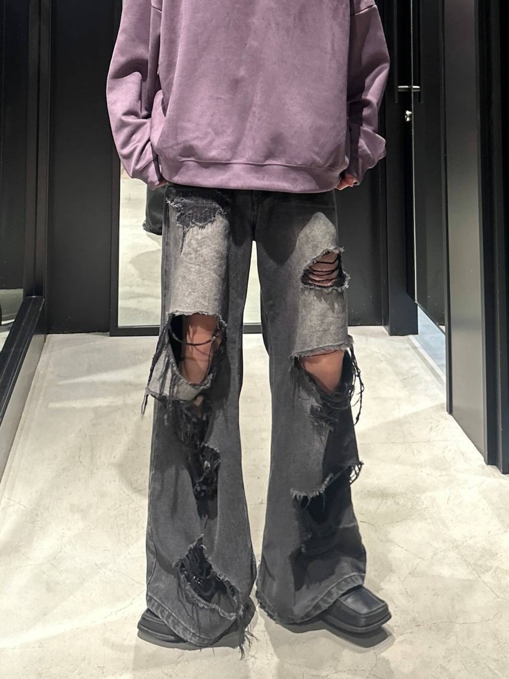ブラック系のデニムパンツ、パープル系のスウェット、グレー系のニットキャップ/ビーニーを着用したメンズの秋コーディネートの3枚目の写真