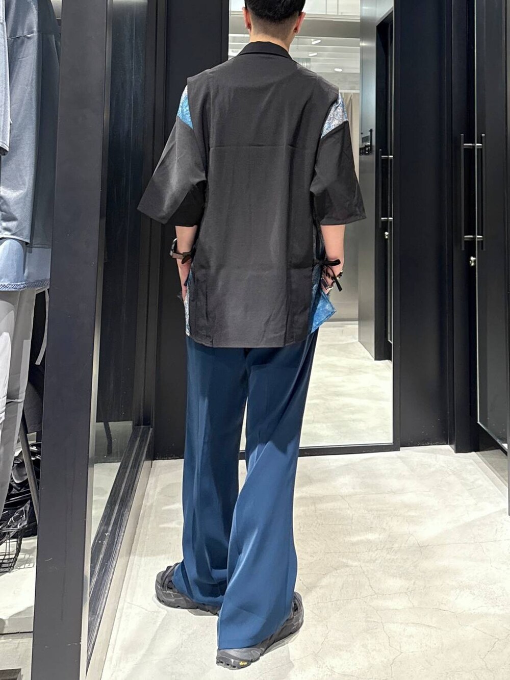 ブルー系のスラックス、ブラック系のサンダル、ブラック系のタンクトップを着用したメンズの夏コーディネートの2枚目の写真