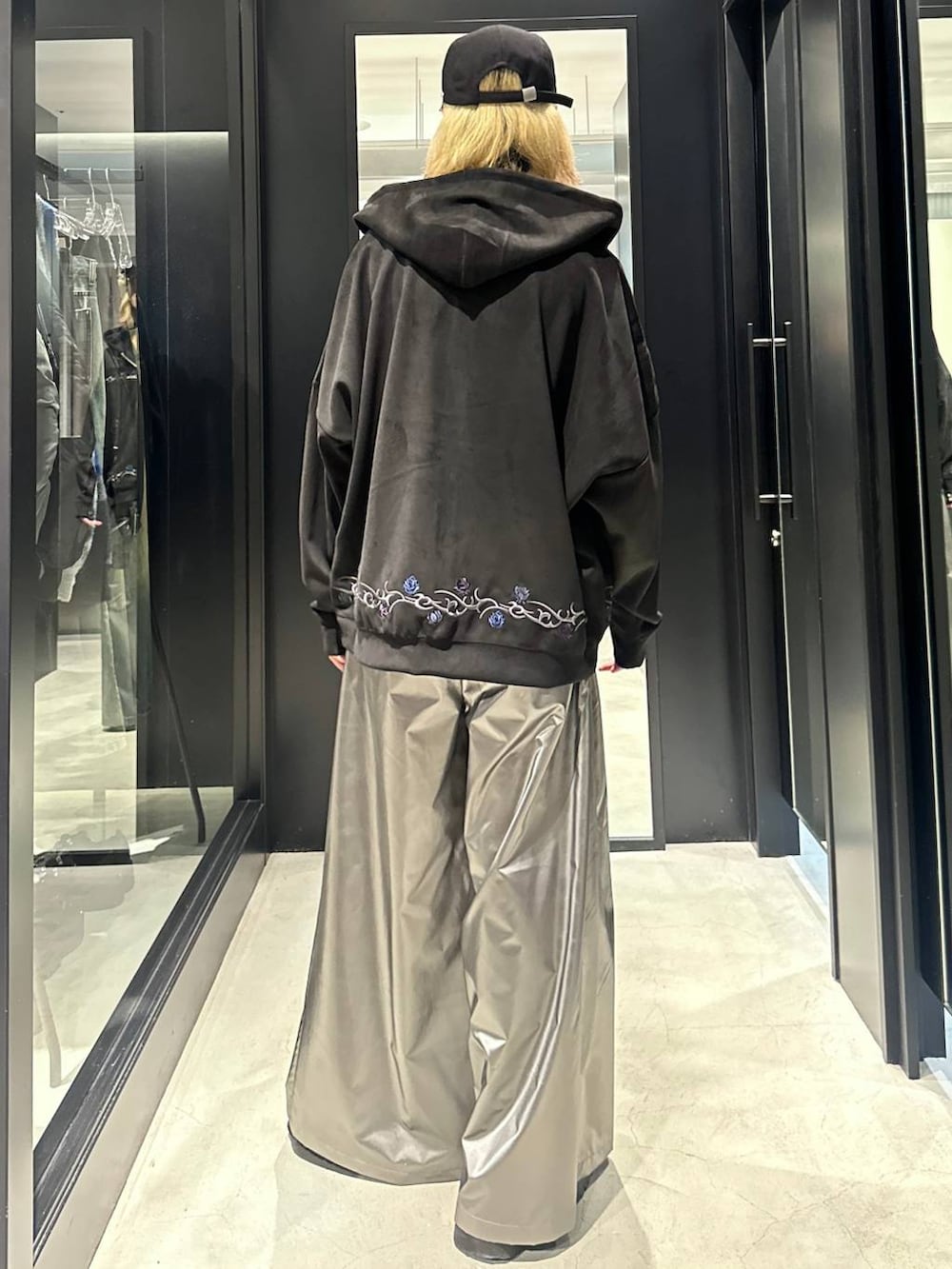 ブラック系のパーカー、シルバー系のスラックス、ブラック系のキャップを着用したメンズの秋コーディネートの4枚目の写真