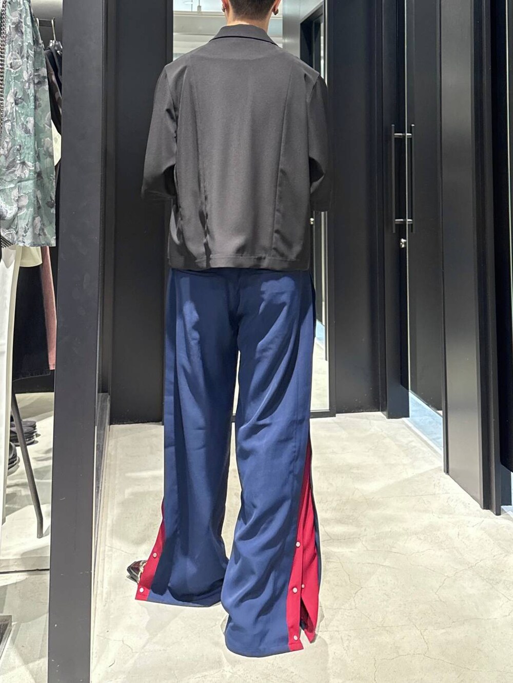 ブラック系のテーラードジャケット、ブラック系のタンクトップ、ブルー系のスラックスを着用したメンズの春コーディネートの3枚目の写真