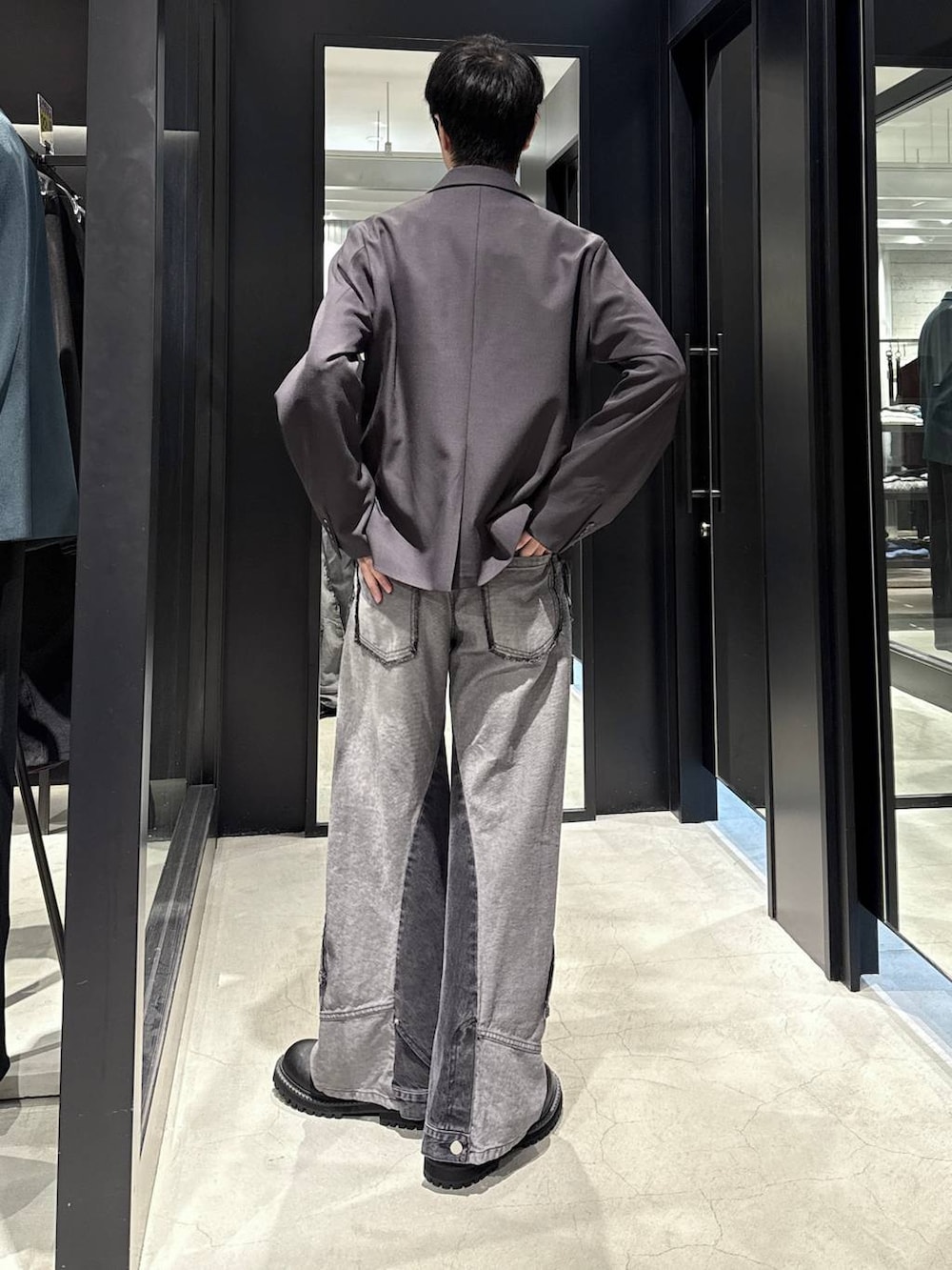 ブラック系のデニムパンツ、ブラック系のTシャツ/カットソー、ブラック系のブーツを着用したメンズの秋コーディネートの3枚目の写真