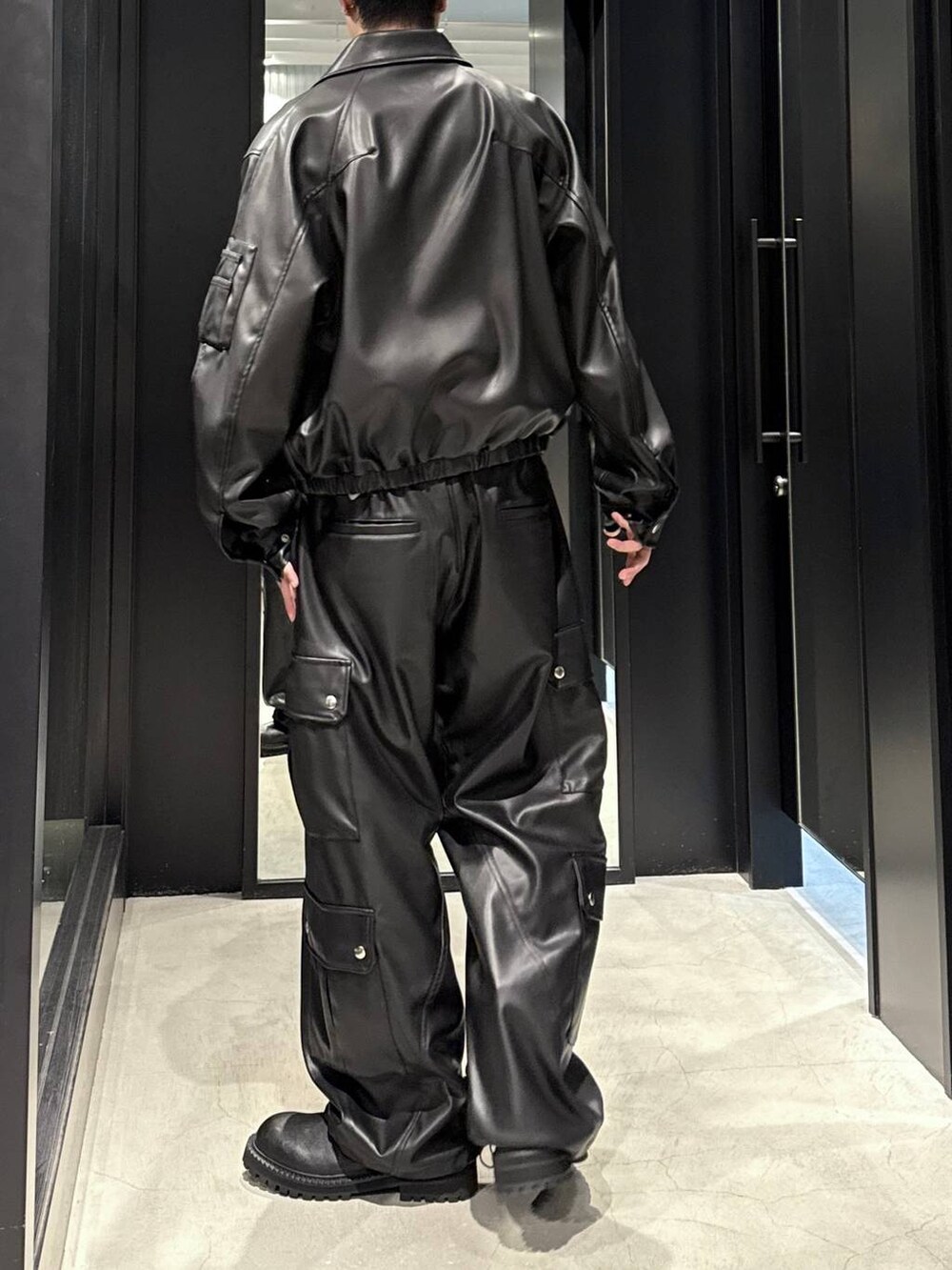 ブラック系のタンクトップ、ブラック系のブルゾン、ブラック系のカーゴパンツを着用したメンズの秋コーディネートの3枚目の写真