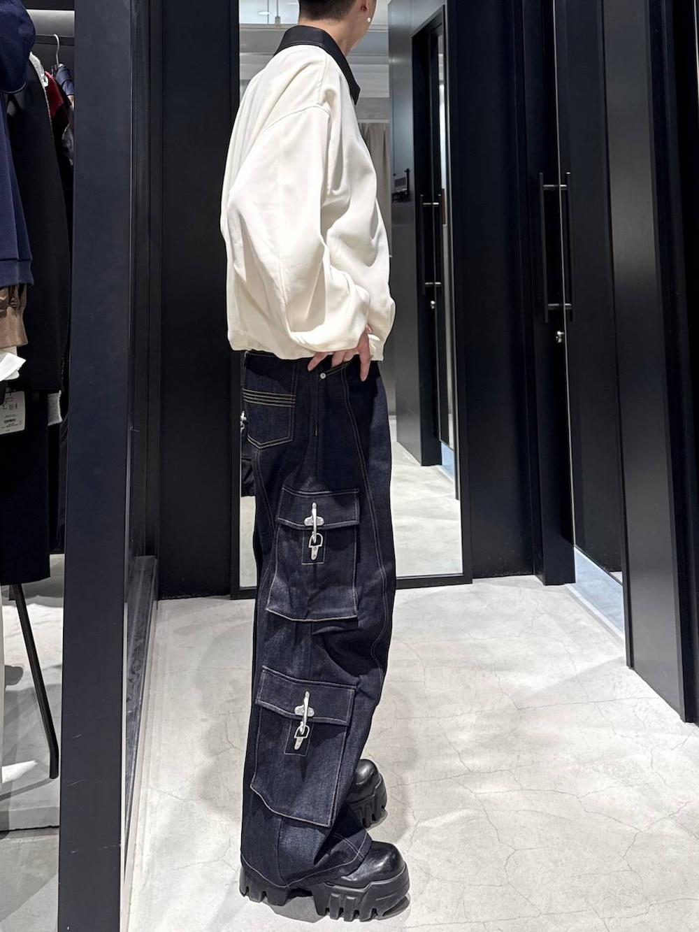 ホワイト系のブルゾン、ブルー系のデニムパンツ、ホワイト系のネックレスを着用したメンズの冬コーディネートの2枚目の写真