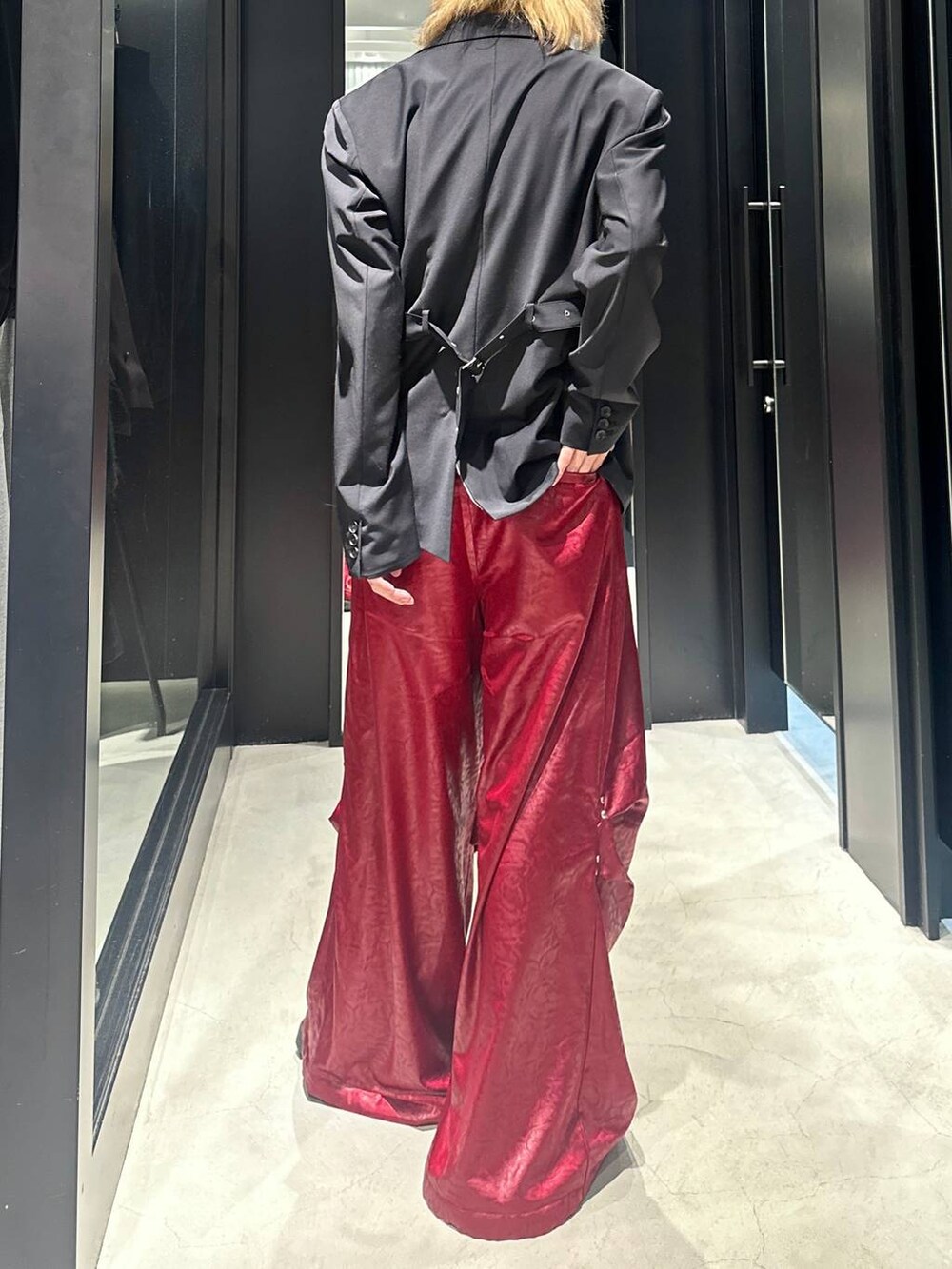 ブラック系のテーラードジャケット、レッド系のその他パンツ、ブラック系のキャップを着用したメンズの秋コーディネートの4枚目の写真