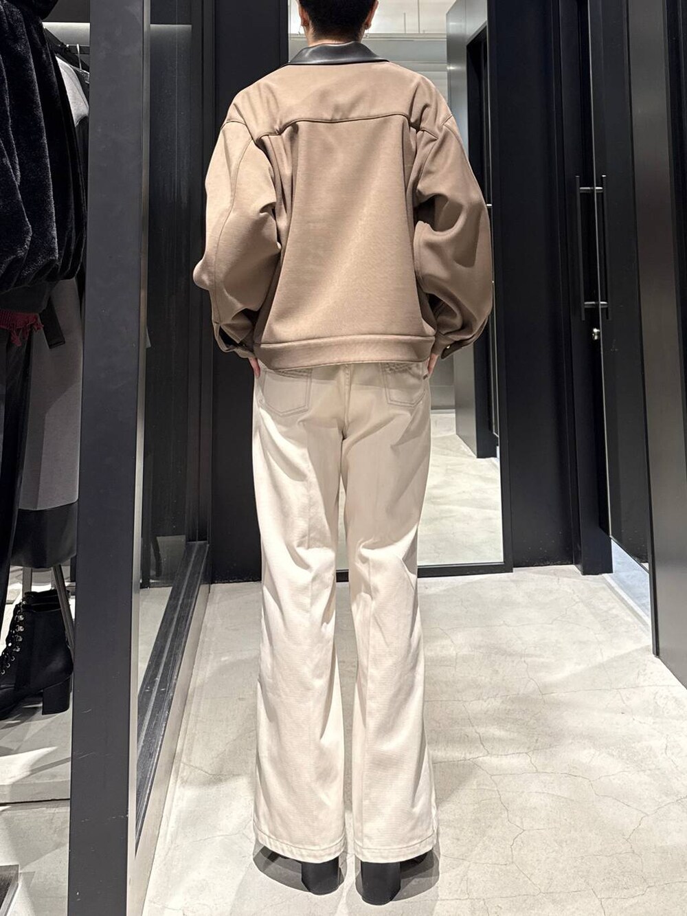 ブラック系のブーツ、ホワイト系のデニムパンツ、ベージュ系のブルゾンを着用したメンズの冬コーディネートの3枚目の写真