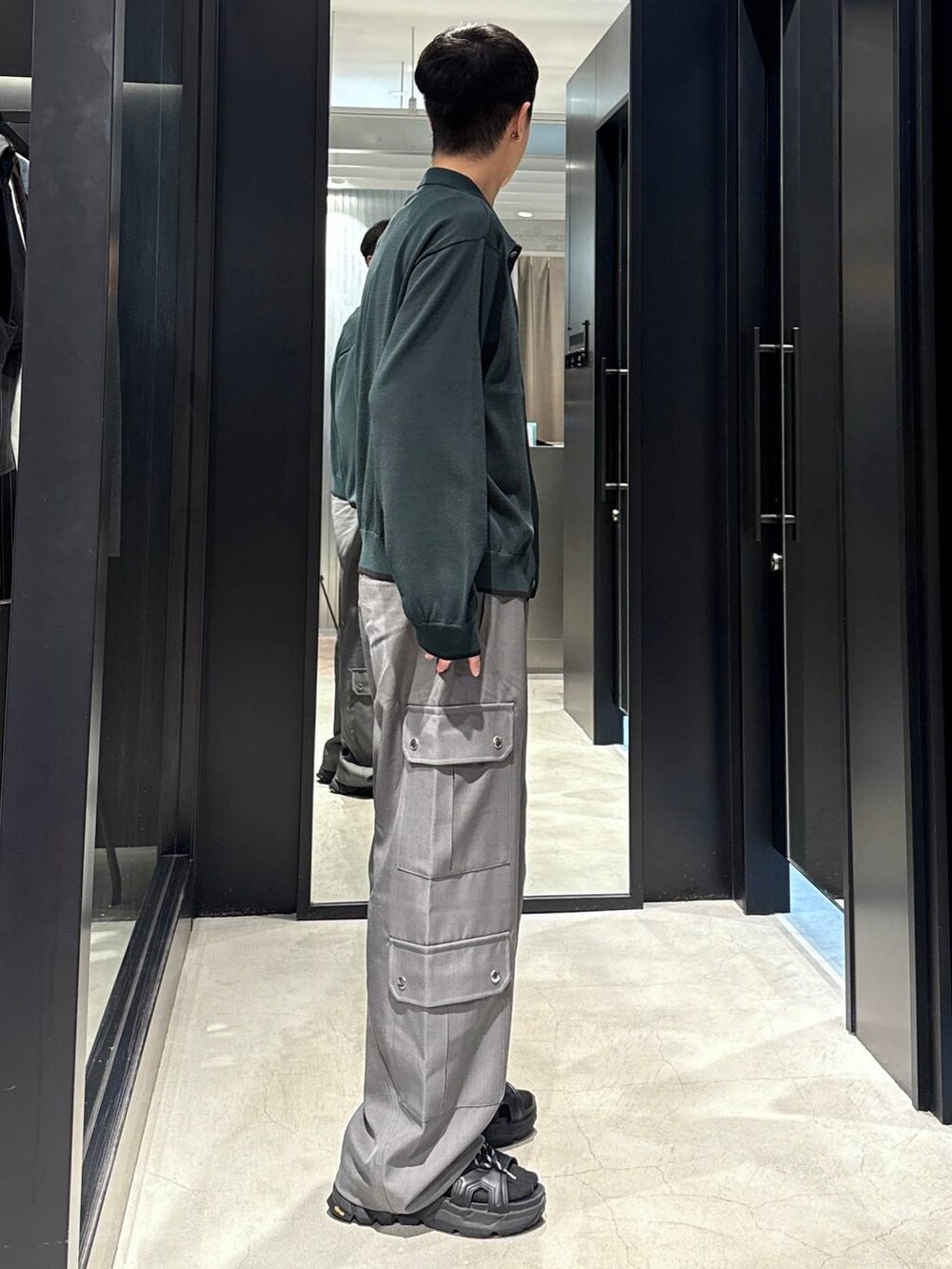 ブラック系のサンダル、ブラック系のタンクトップ、グレー系のカーゴパンツを着用したメンズの夏コーディネートの2枚目の写真