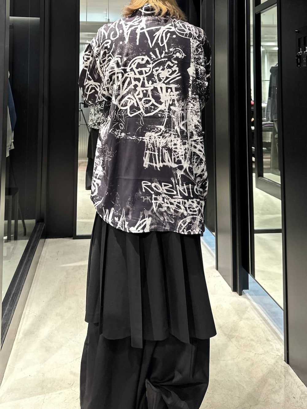 ブラック系のスラックス、ブラック系のブーツ、ブラック系のシャツ/ブラウスを着用したメンズの秋コーディネートの3枚目の写真