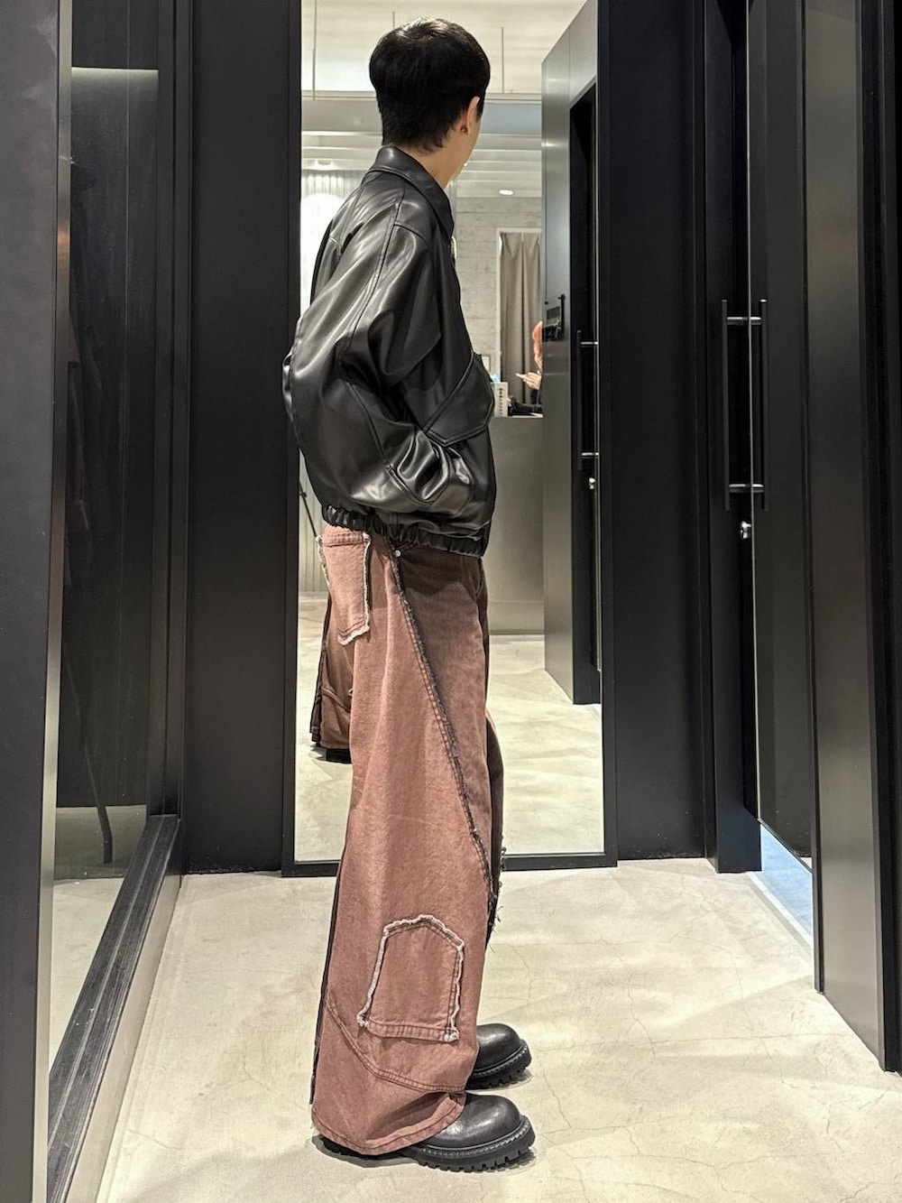 ホワイト系のTシャツ/カットソー、ブラック系のブルゾン、レッド系のデニムパンツを着用したメンズの秋コーディネートの2枚目の写真