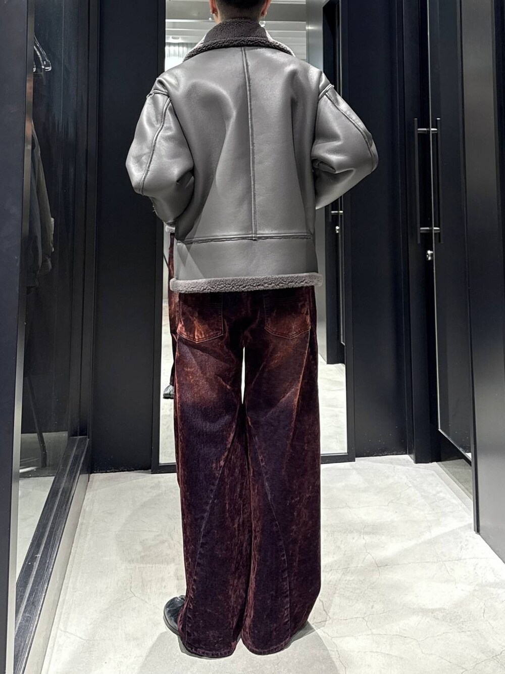 グレー系のブルゾン、レッド系のデニムパンツを着用したメンズの秋コーディネートの3枚目の写真