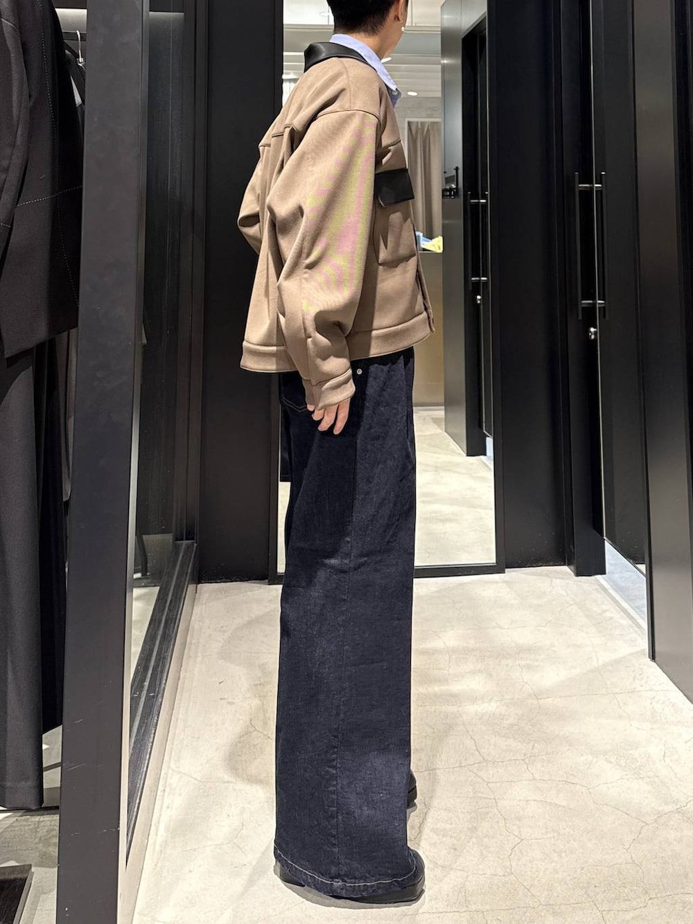 ブラック系のブーツ、ブルー系のデニムパンツ、ベージュ系のブルゾンを着用したメンズの冬コーディネートの2枚目の写真