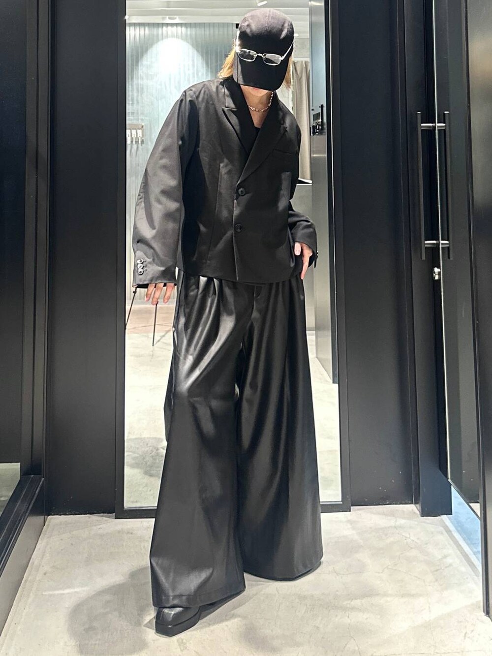 ブラック系のその他パンツ、ブラック系のブーツ、ブラック系のテーラードジャケットを着用したメンズの秋コーディネートの4枚目の写真
