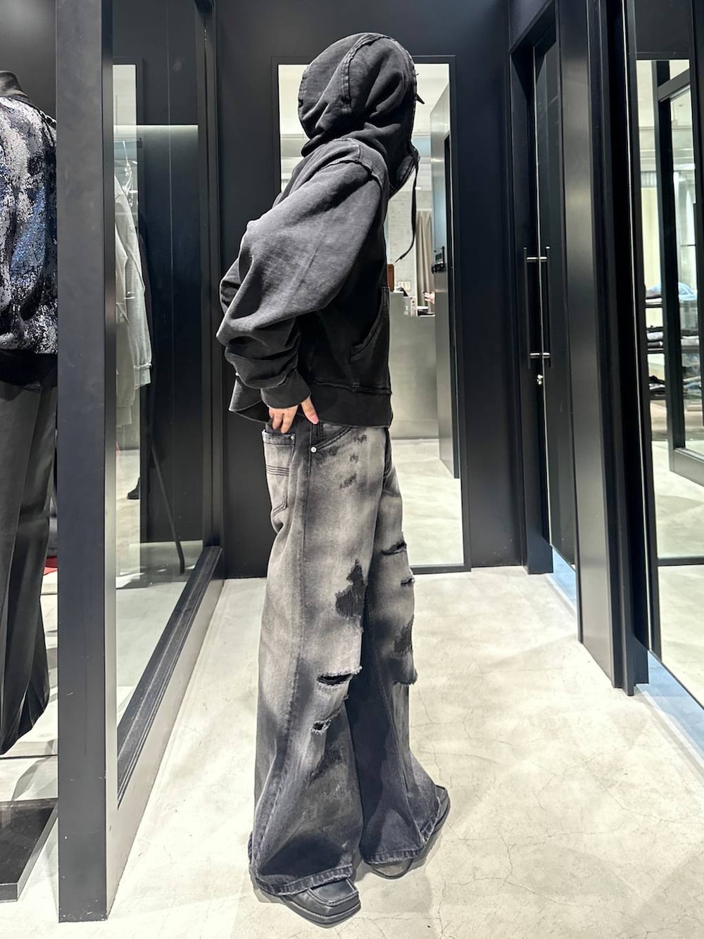 ブラック系のデニムパンツ、ブラック系のパーカー、ブラック系のキャップを着用したメンズの秋コーディネートの2枚目の写真